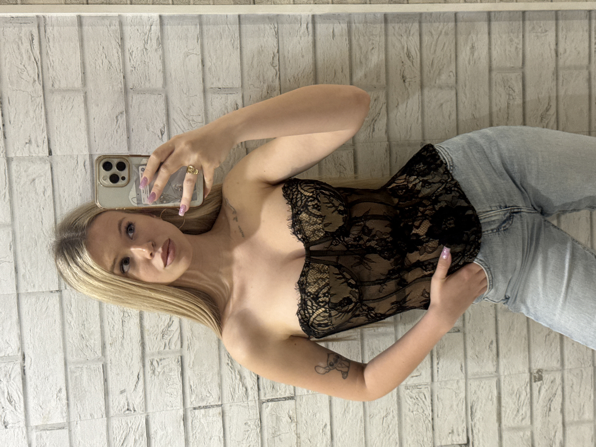 Selfie in black lace corset and light wash jeans