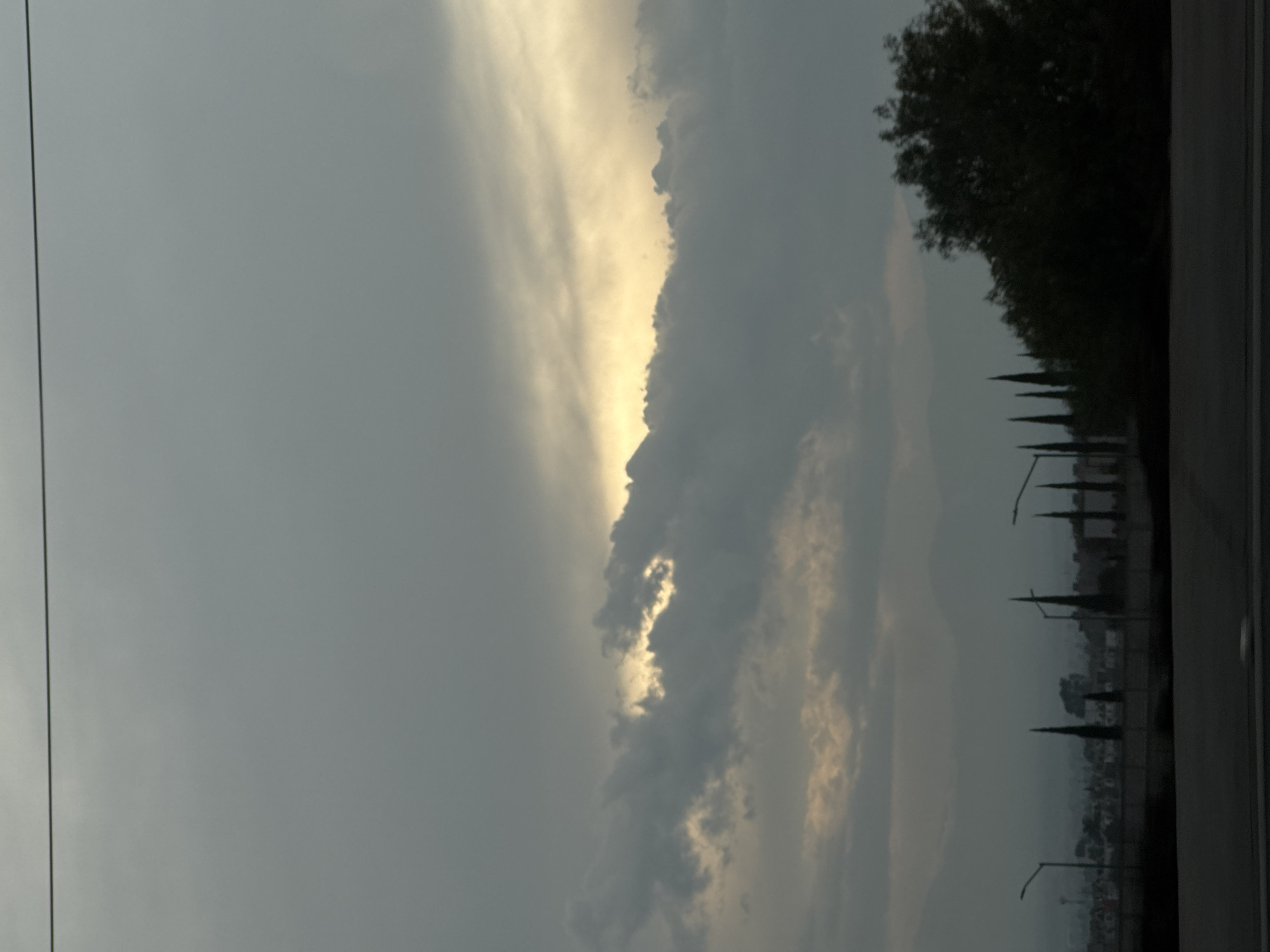 Evening sky observation shows yellow light through grey clouds