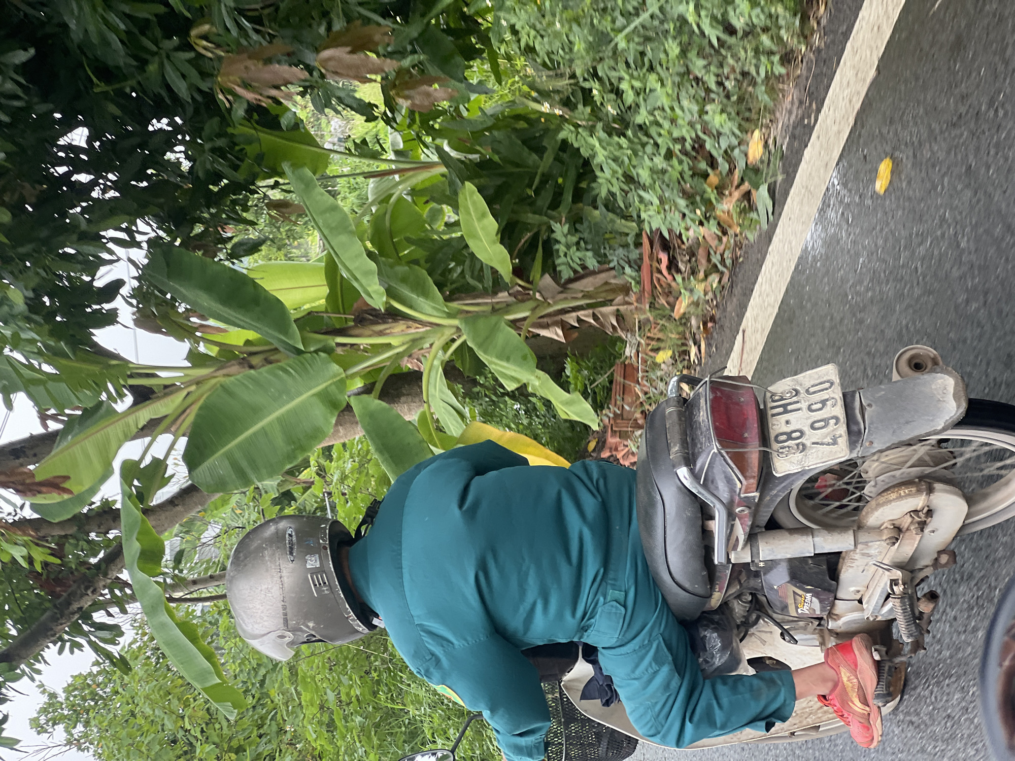 Hanoi school complex and motorcycle rider, cloudy morning