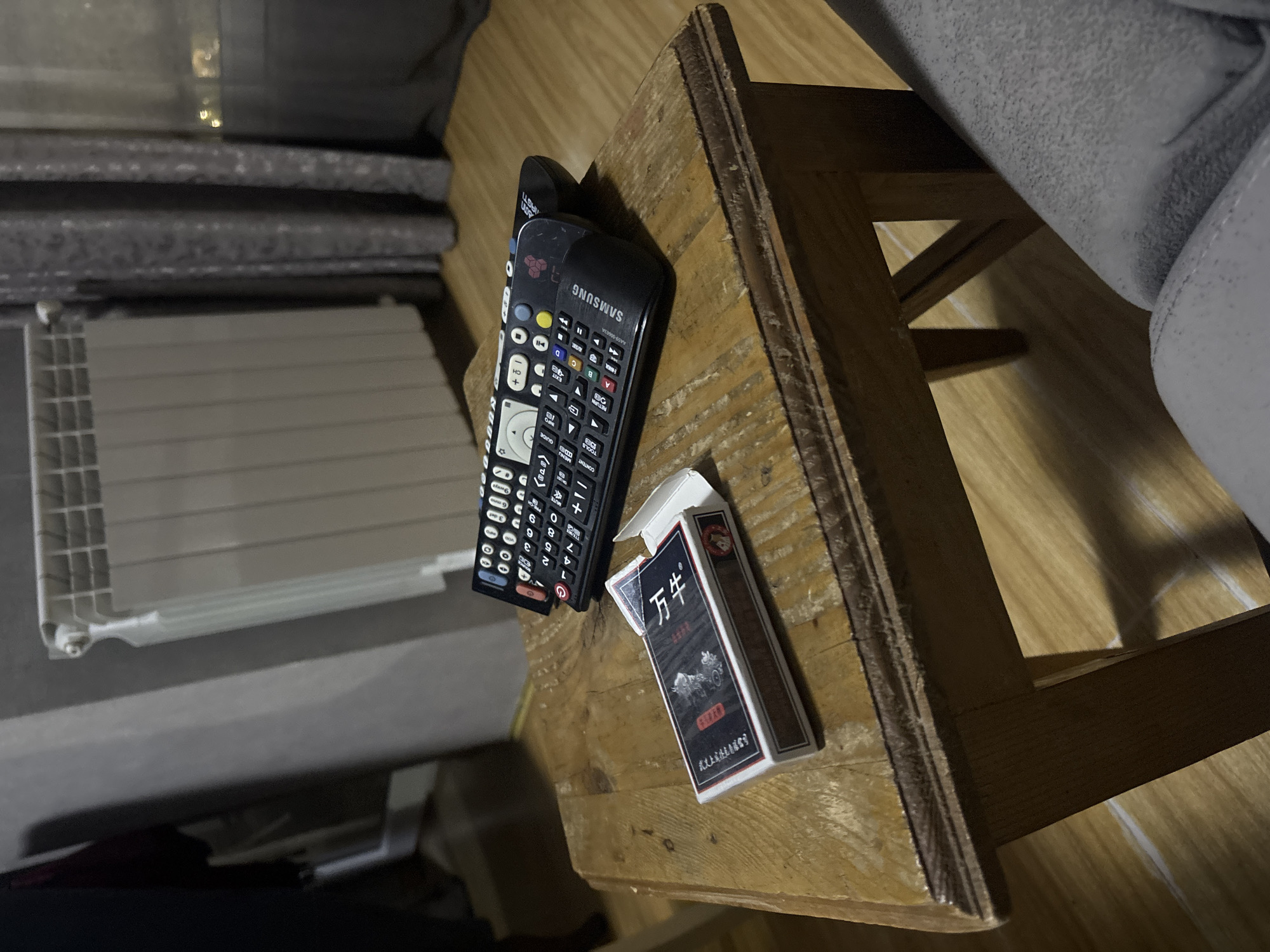 Personal items documented on wooden surface in dim lighting