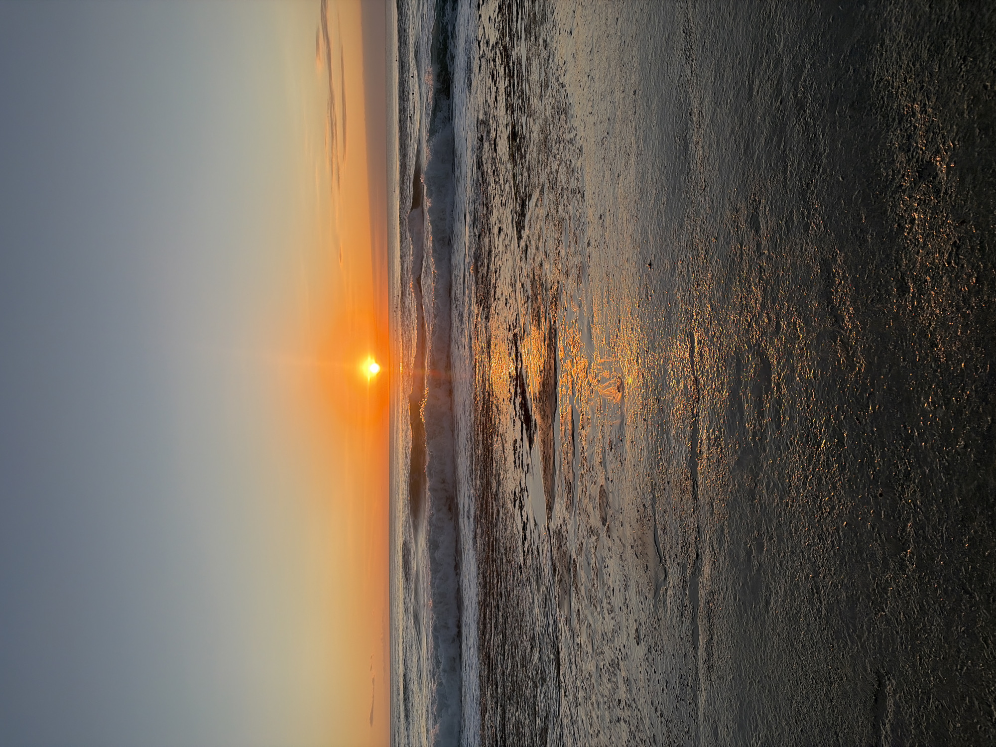 Golden sunset over the beach, sand, and breaking waves