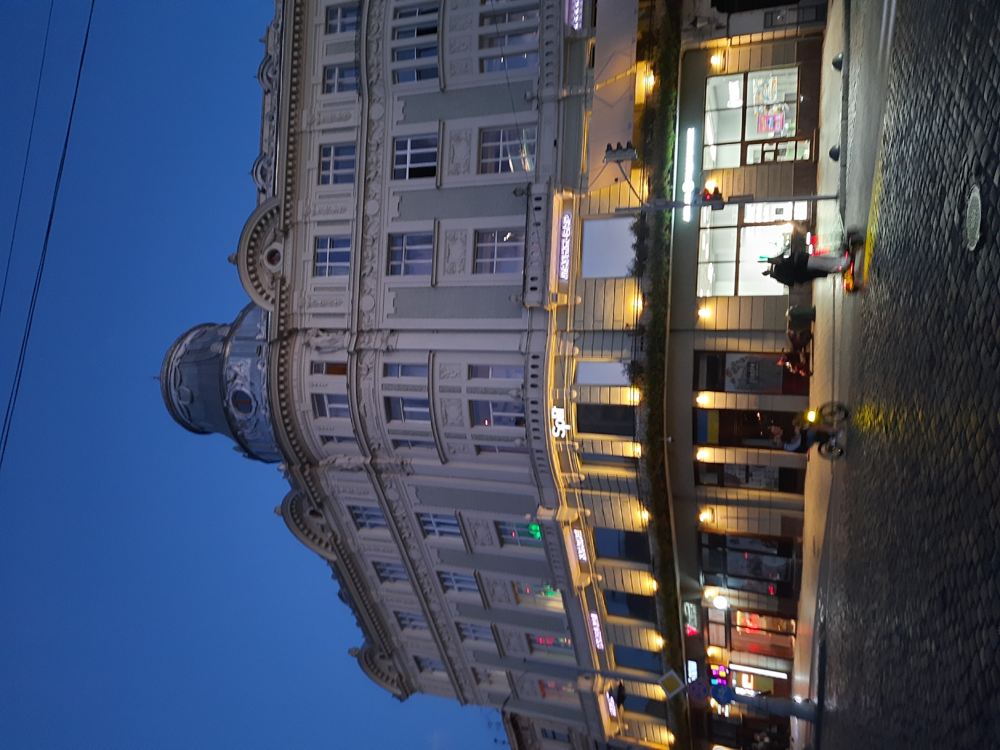 Ornate domed building at dusk on a Lviv street