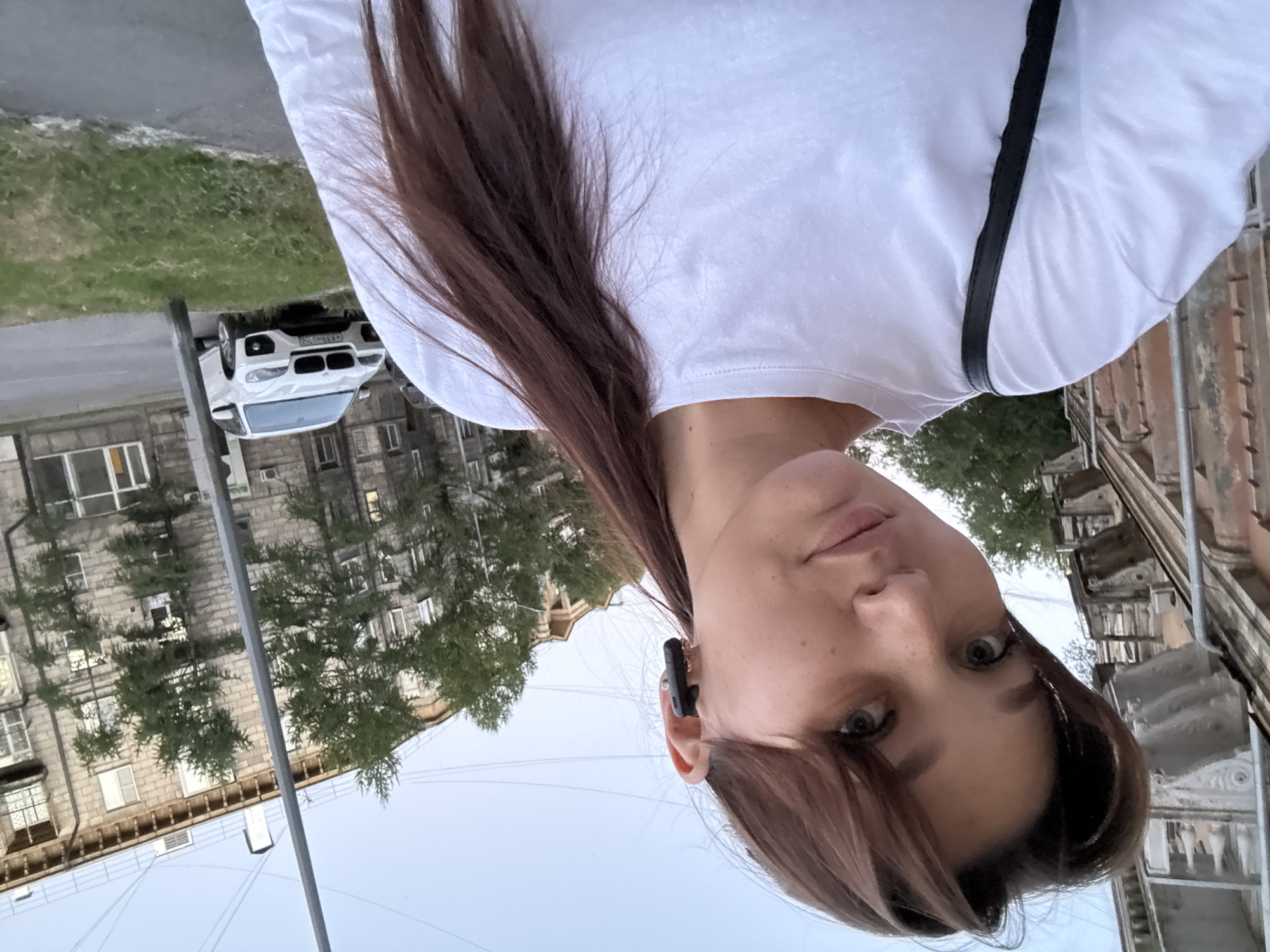 Selfie session outside a Novokuznetsk apartment block, summer evening
