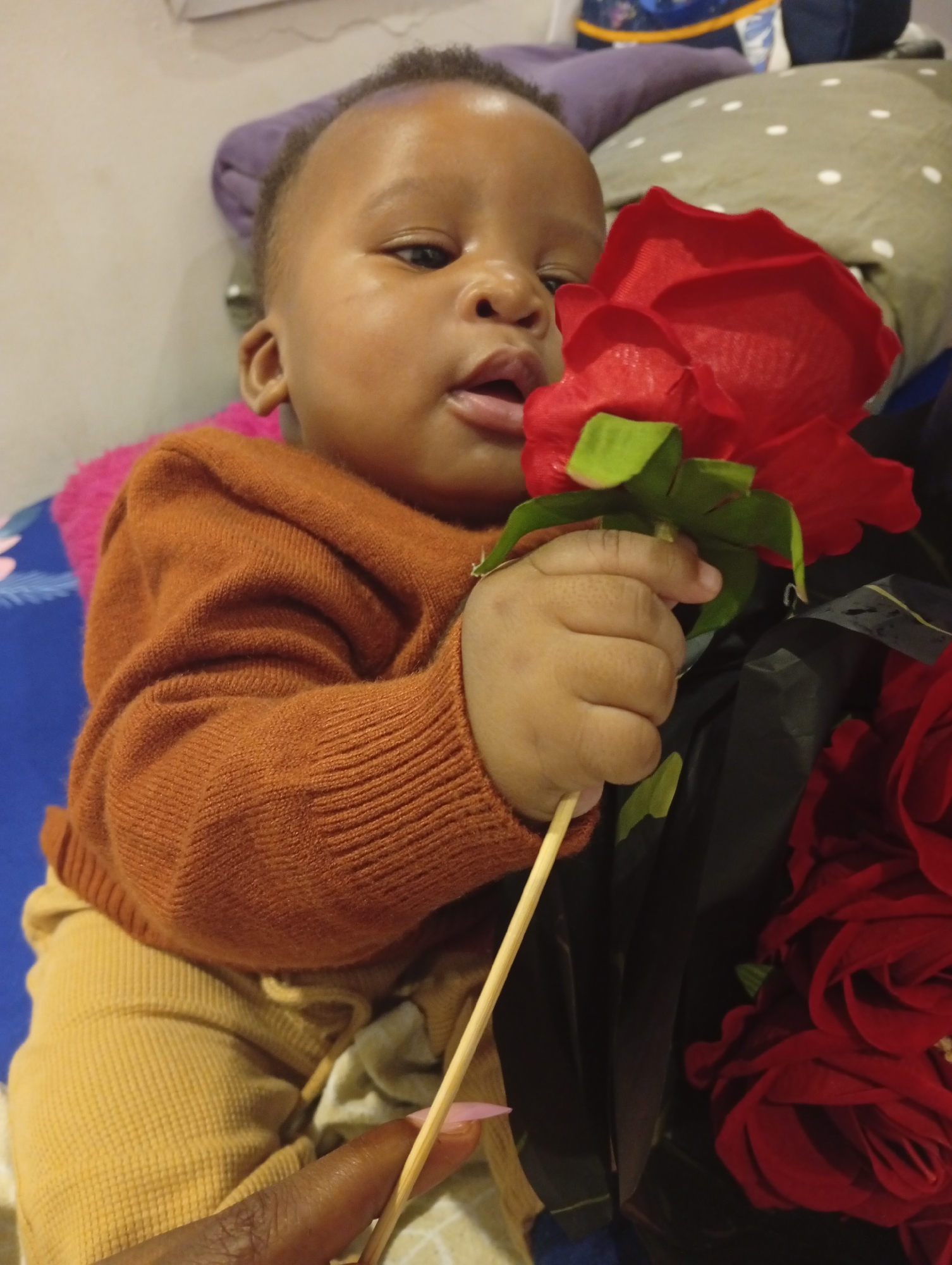 Baby with roses and '28' balloons at a celebration in Abuja