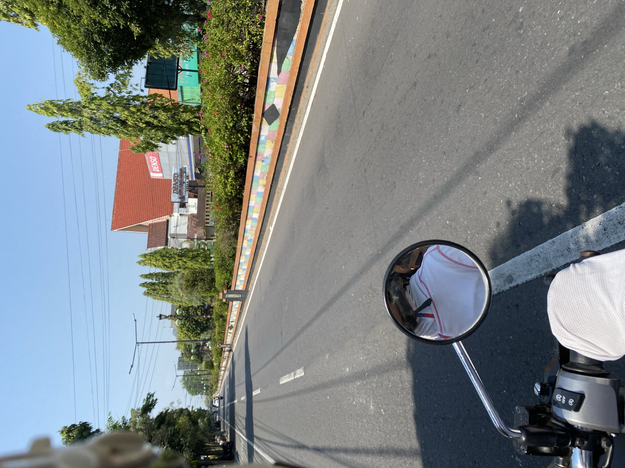 POV motorcycle ride through a sunlit Madiun street