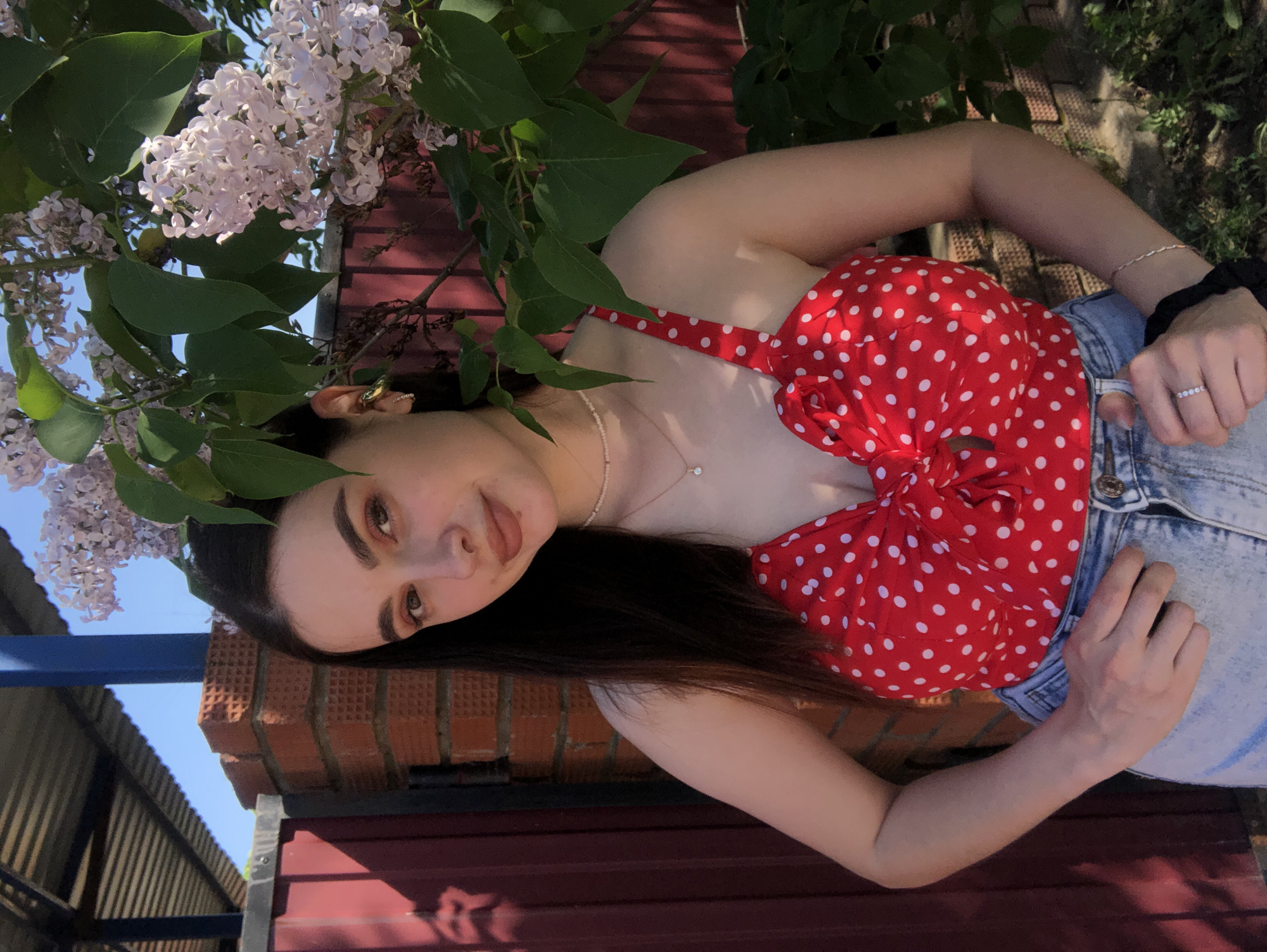 Woman poses with blooming lilacs during photo session in Noviy