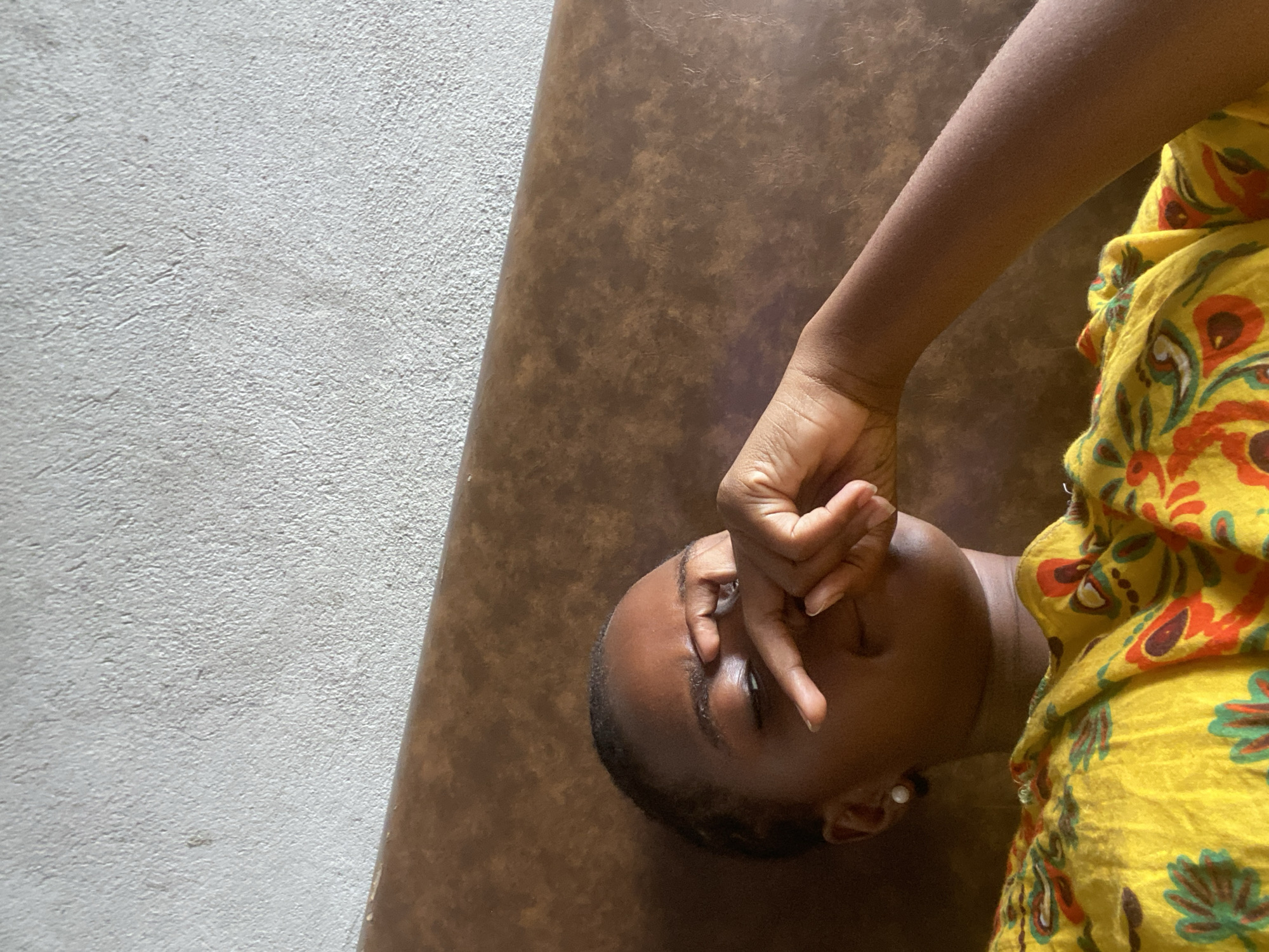 Woman rests at home in Dar es Salaam morning scene