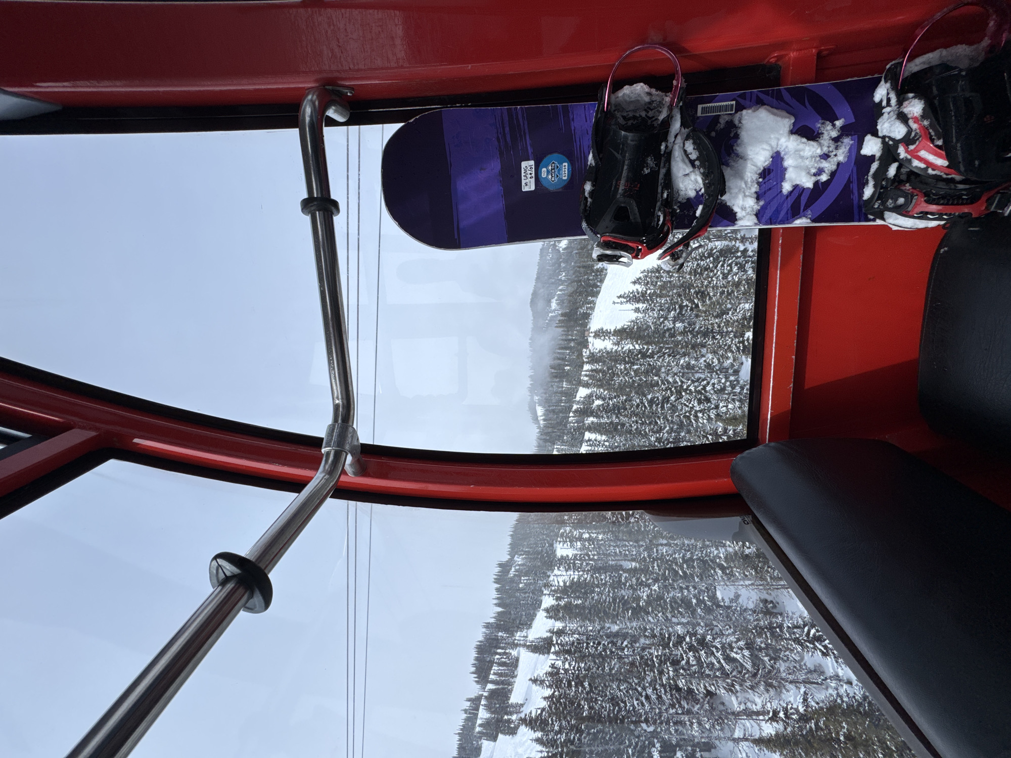 Skiers take selfies in Whistler gondola over snowy mountains