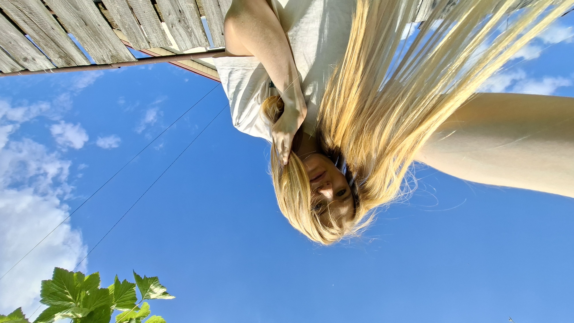 Woman takes garden selfies with pink peonies in Russian village