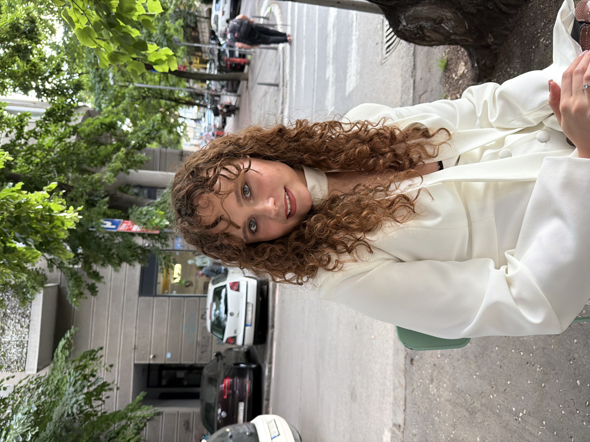 Woman in white enjoys outdoor gathering with flowers in Belgrade