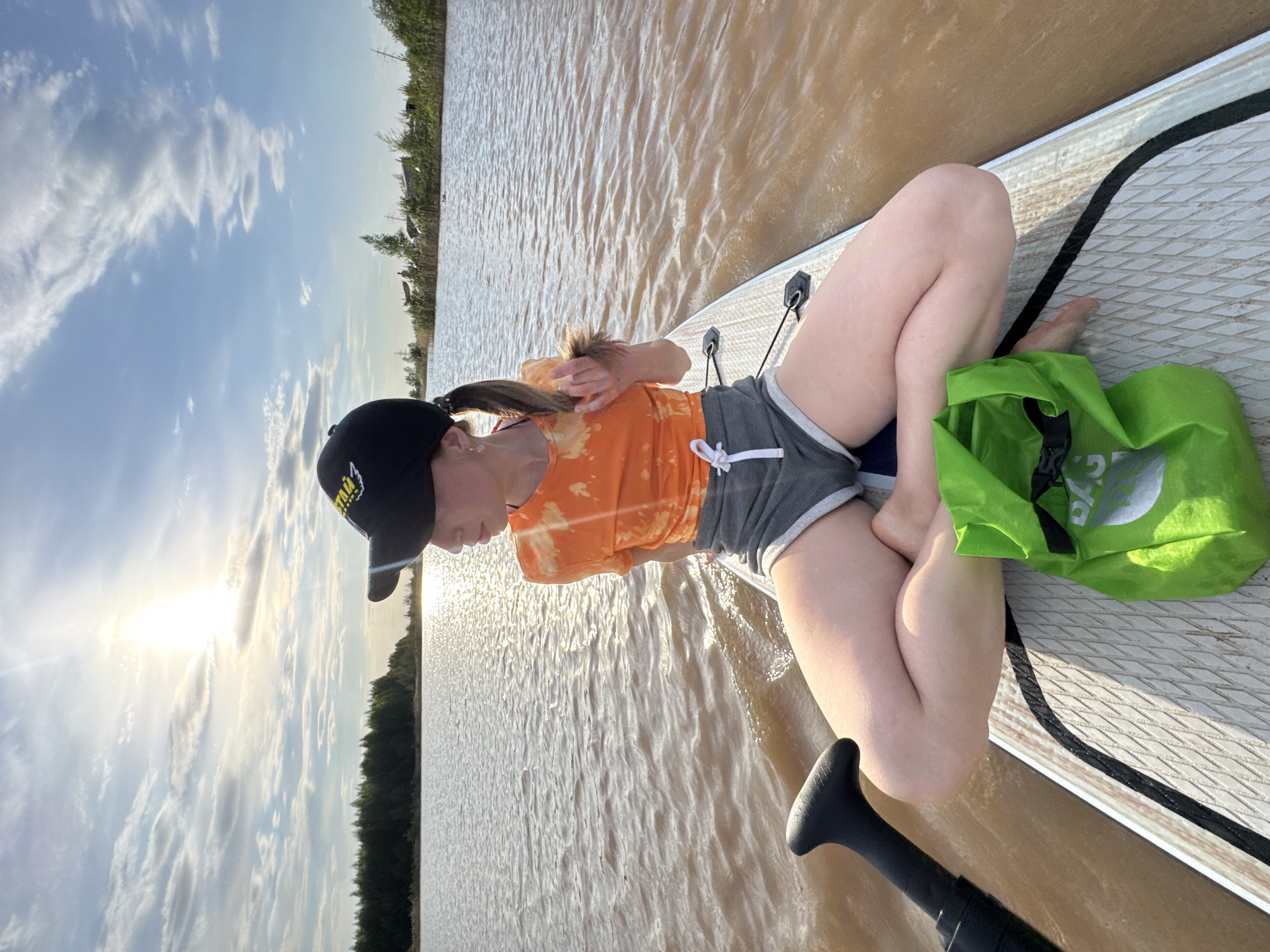 Woman paddleboards on muddy waters in Noviy, Russia