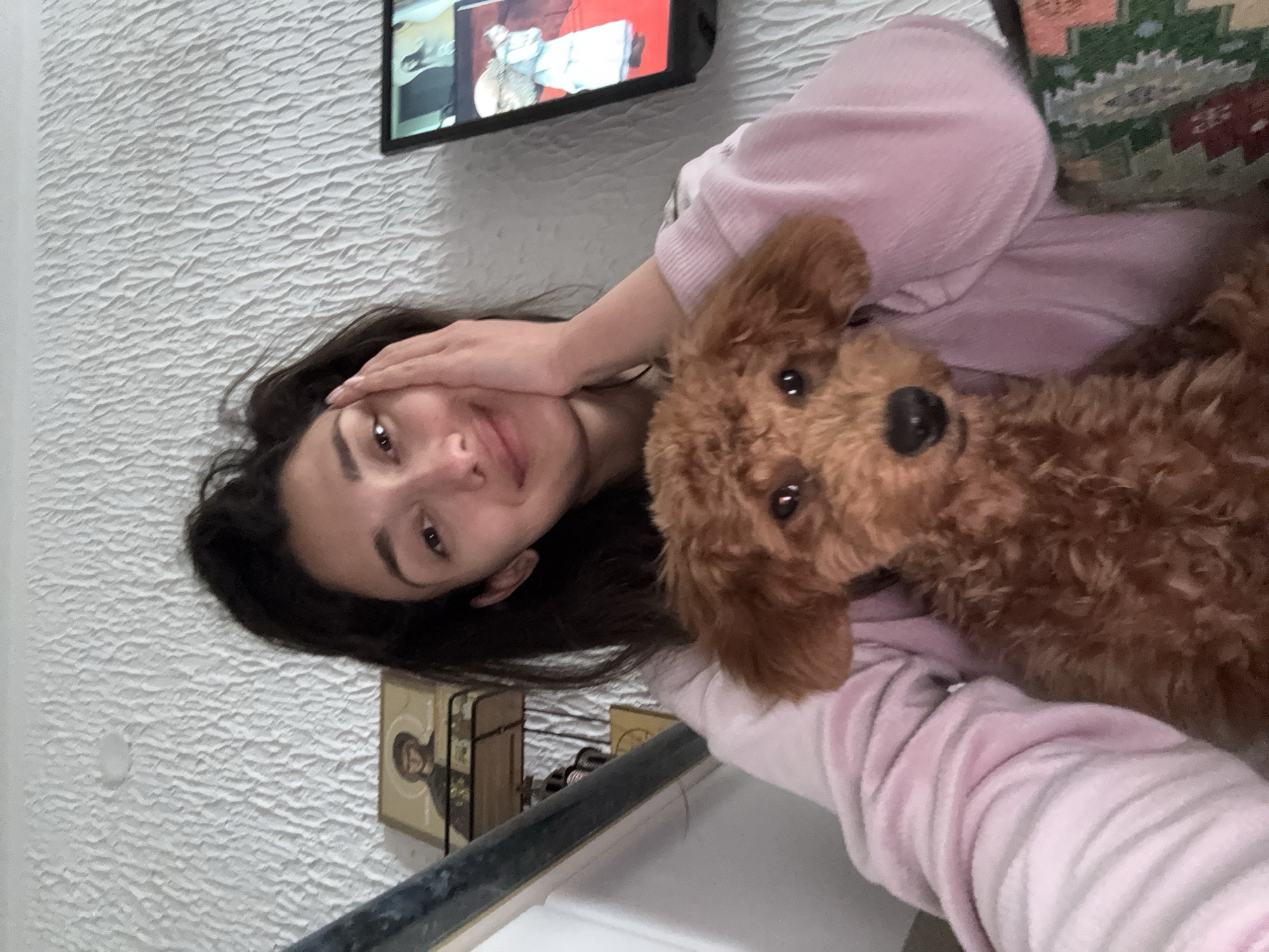 Woman relaxes at home with poodle, takes selfies