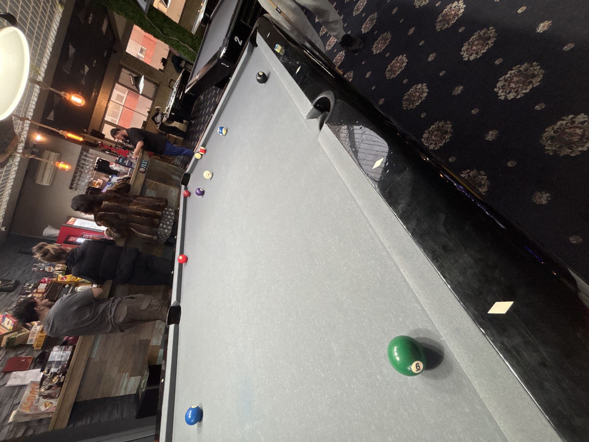 Patrons gather around pool table at Plovdiv bar