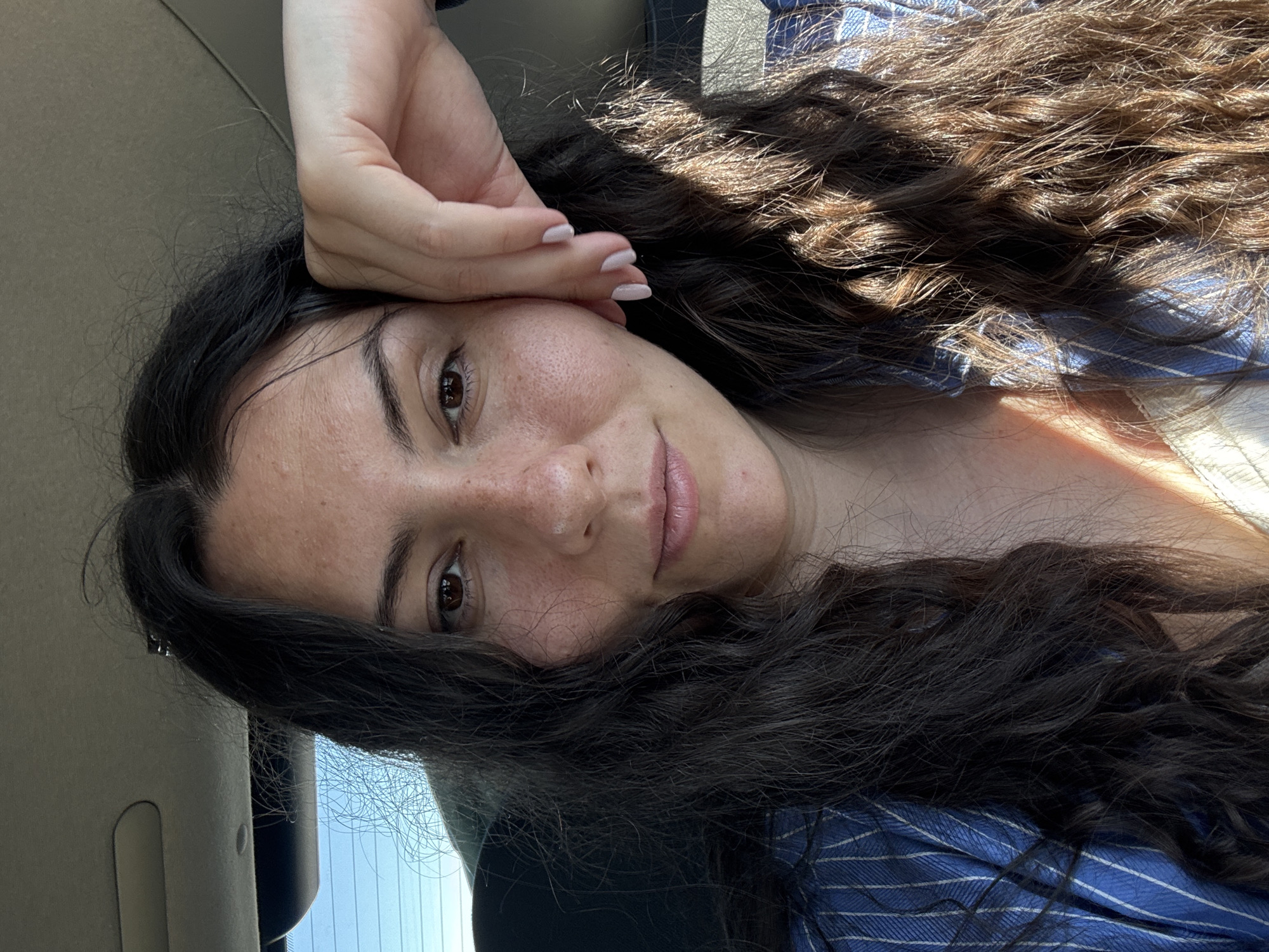 Woman takes selfies while reclining in moving vehicle