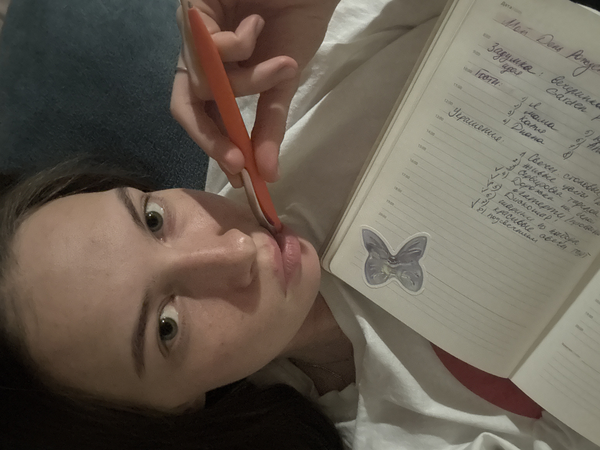 Woman journals in bed during evening in Perm, Russia
