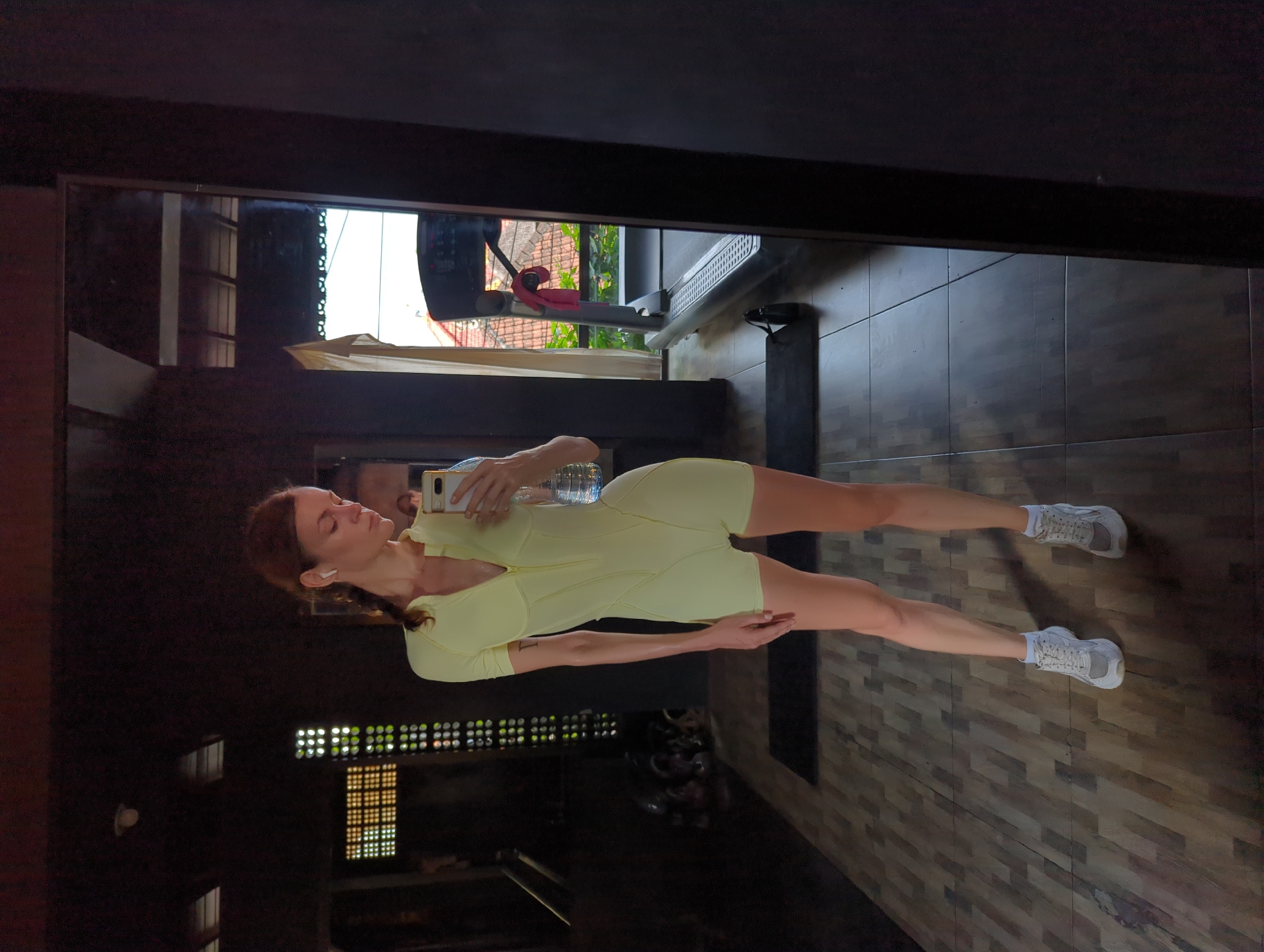 Woman exercises at Mengwi gym, takes selfie during workout