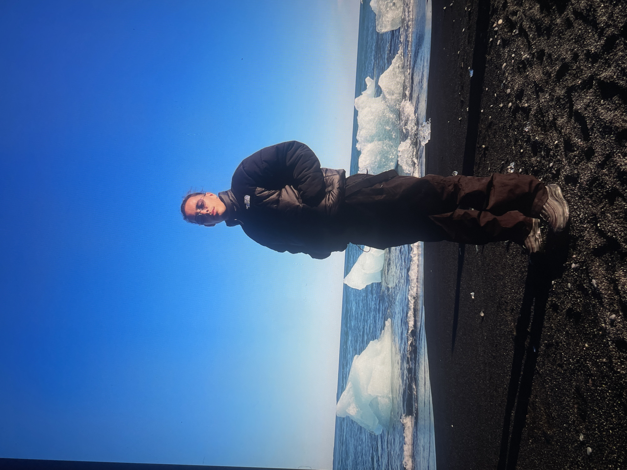 Tourists gather on Iceland's black sand beach amid icebergs