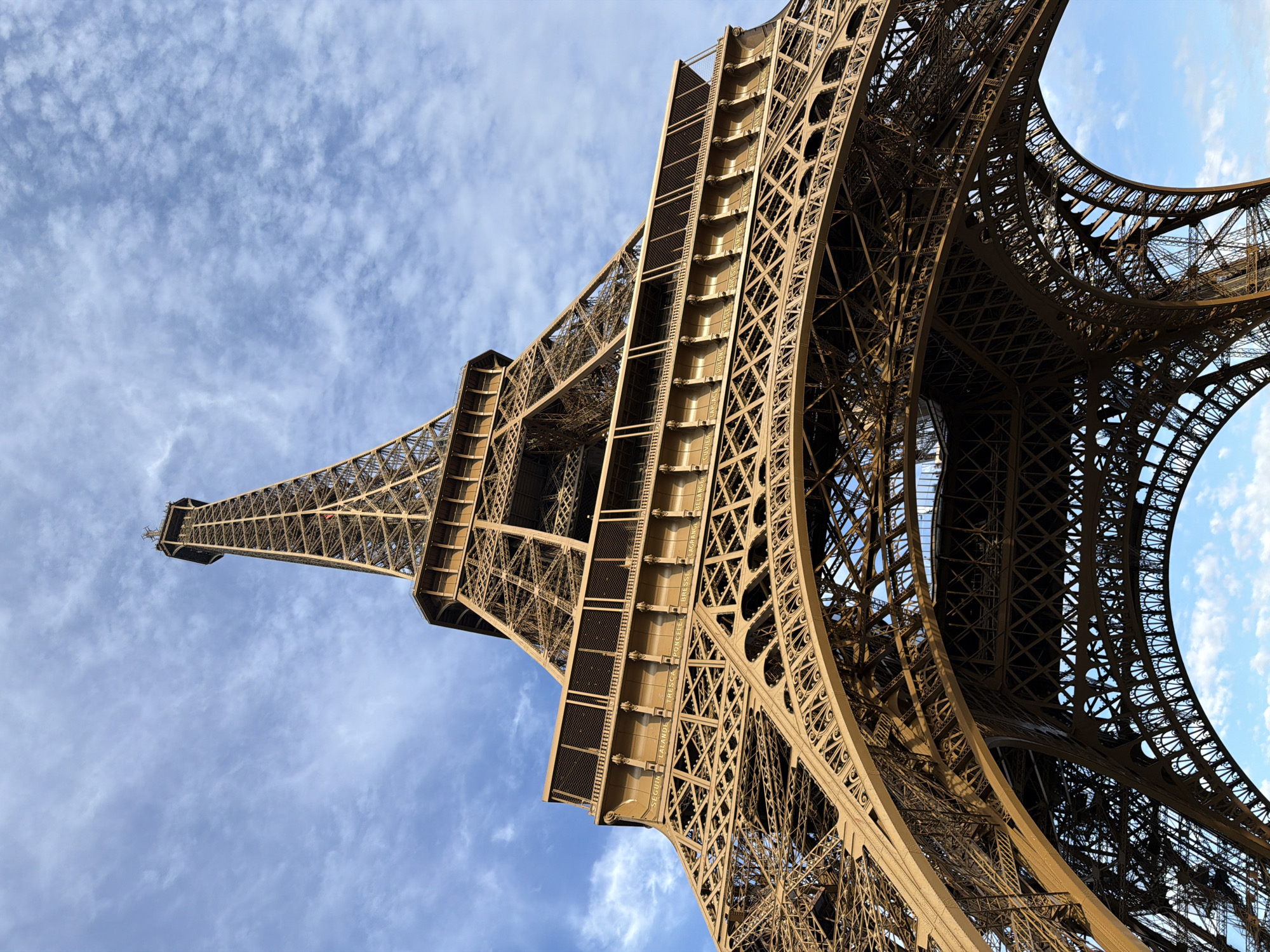 Eiffel Tower iron lattice reaching into a clear Paris sky