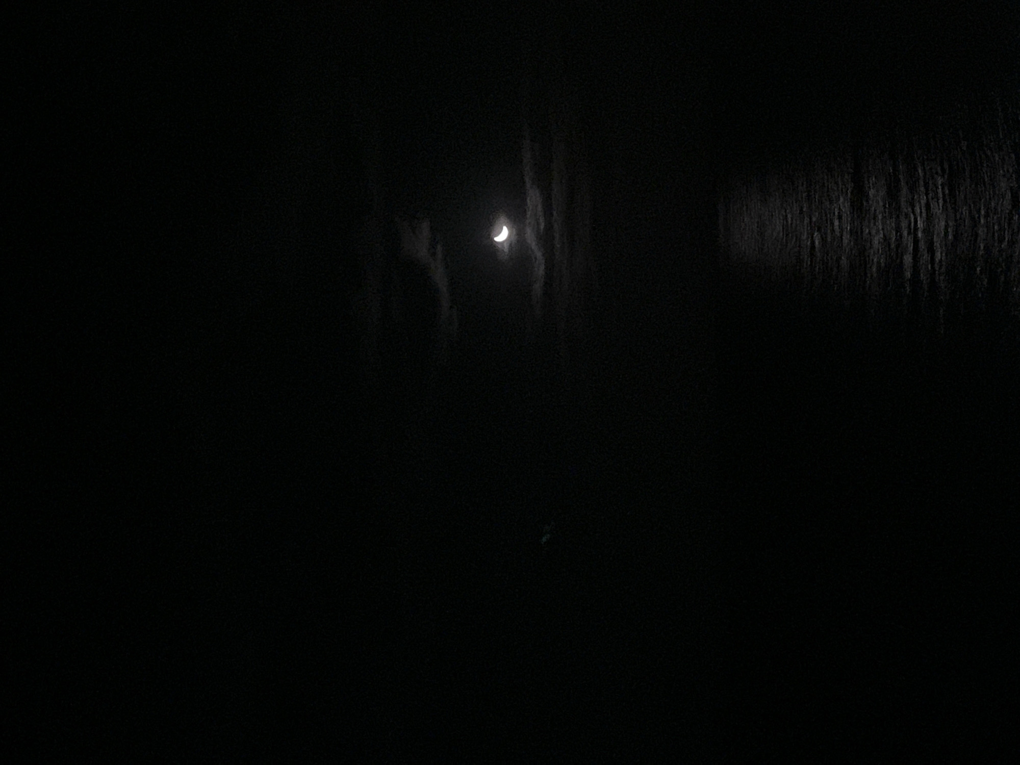 Nighttime maritime observation captures moonlit crane, compass, distant lights