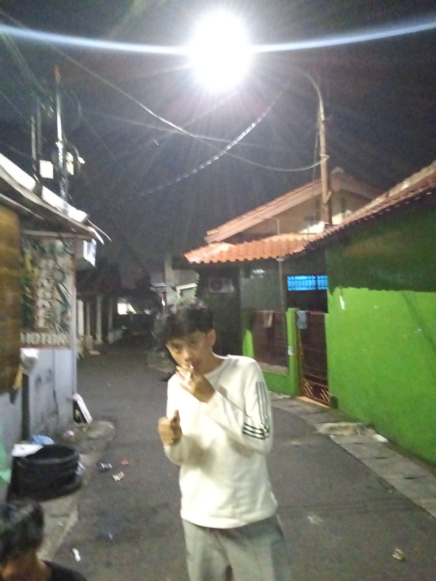 Late-night hangout in a Depok alleyway, cards and all