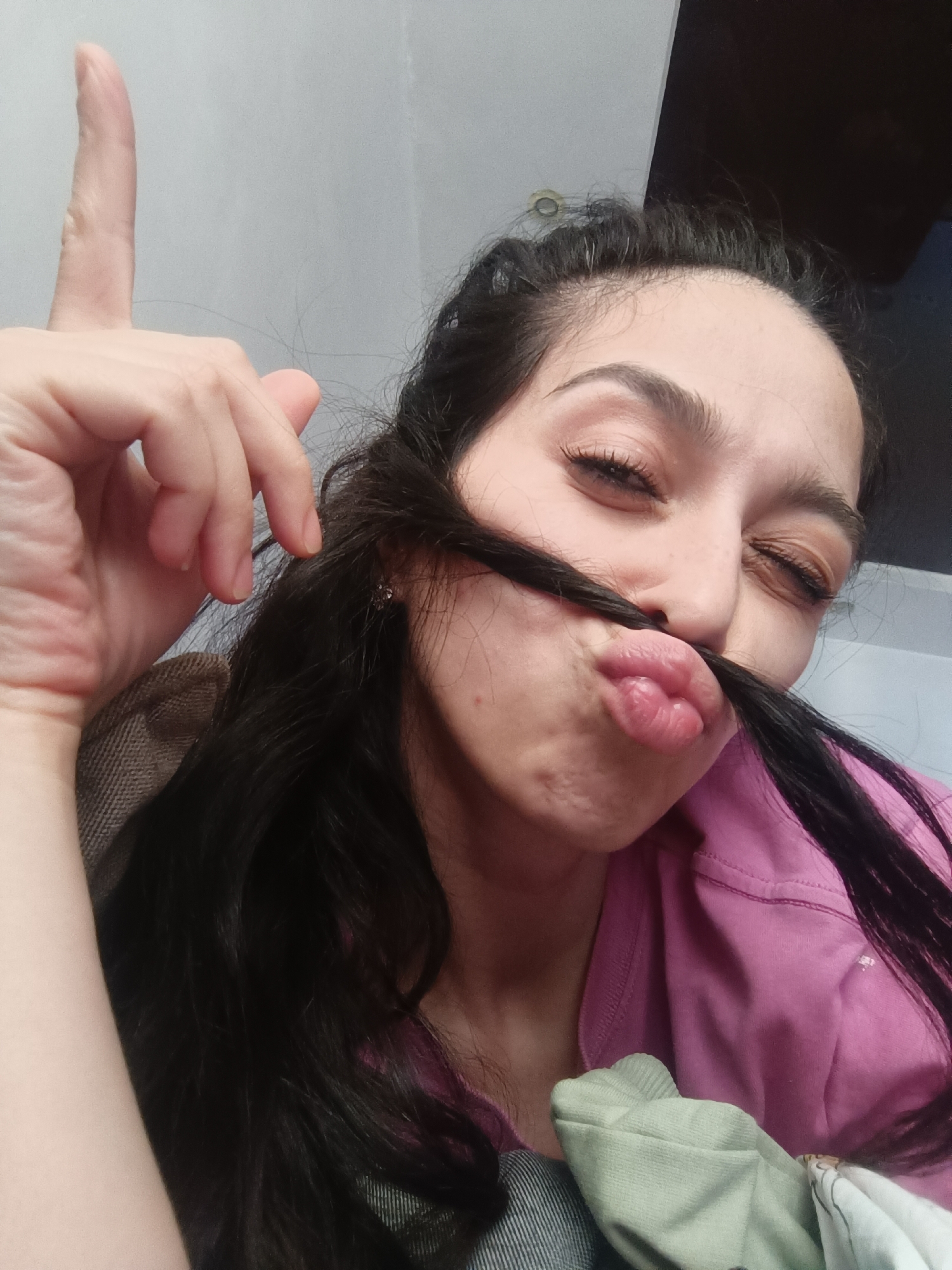 Woman creates makeshift hair mustache indoors in Simferopol