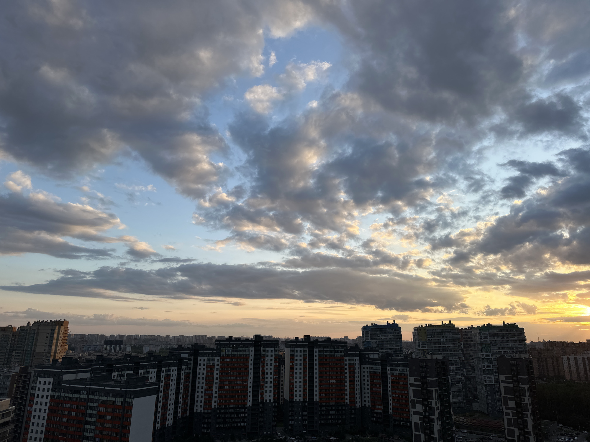 Sinyavino skyline at golden hour, clouds and apartment blocks