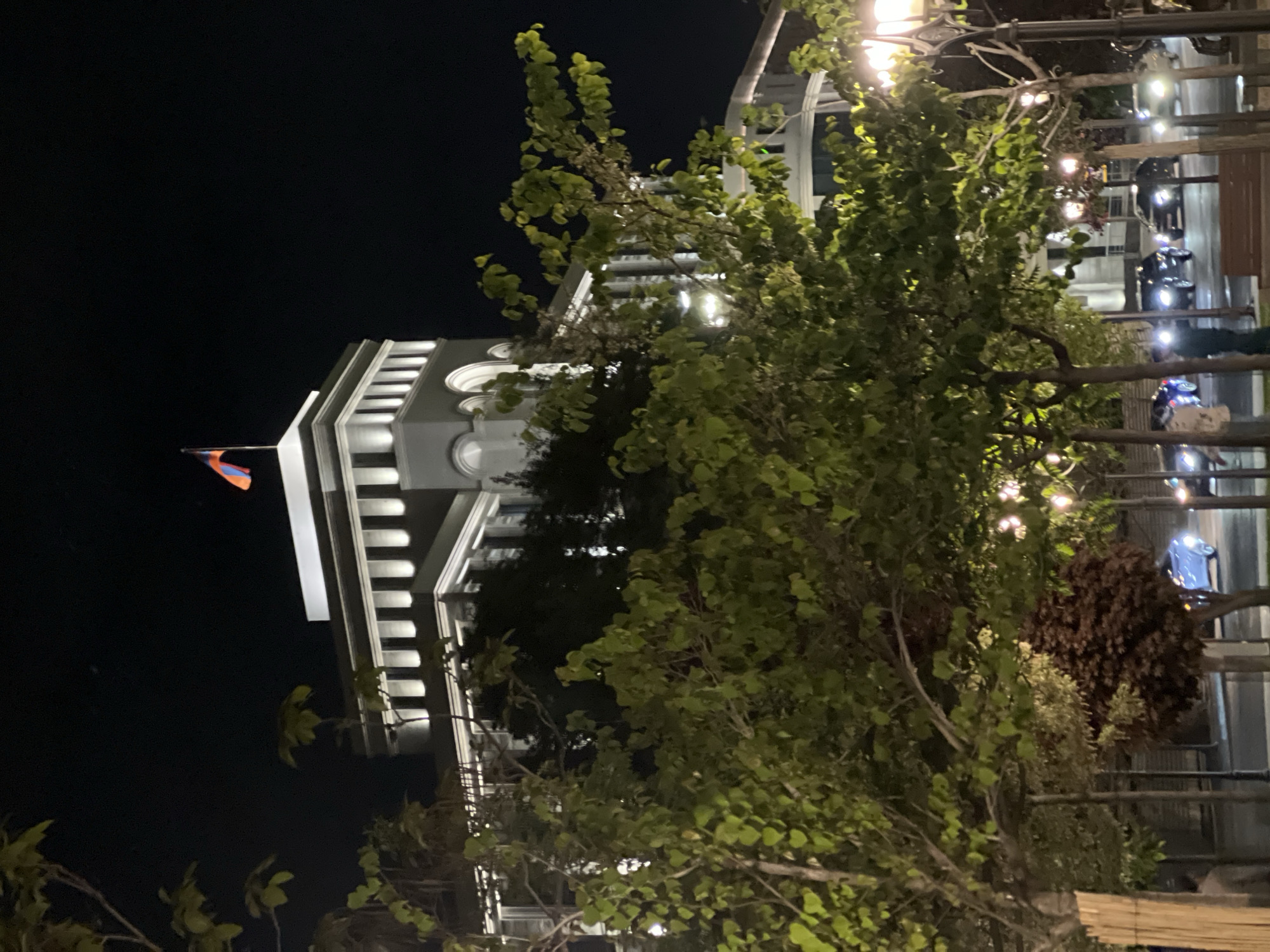 Illuminated government building with Armenian flag observed in Yerevan