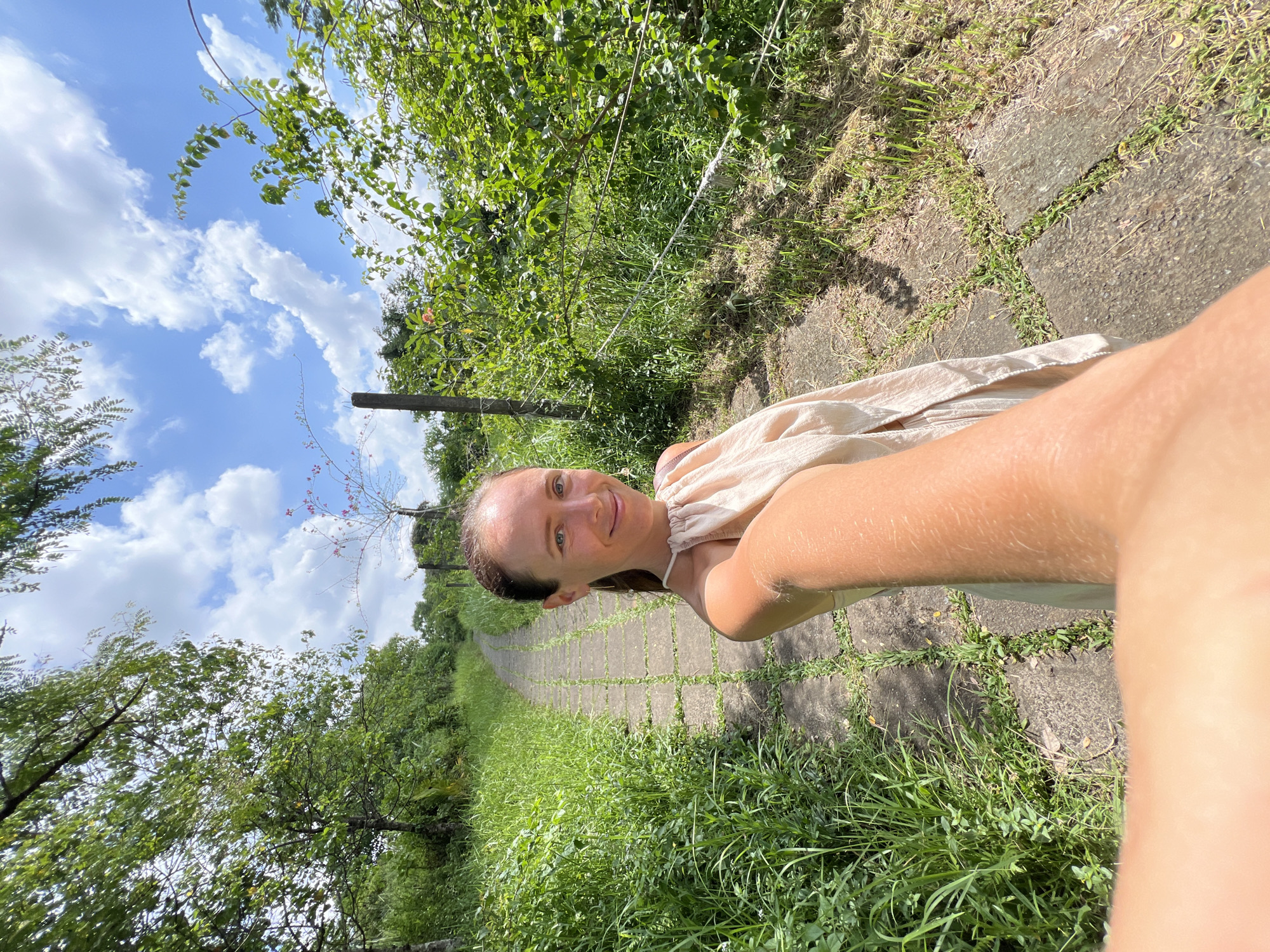 Woman takes selfie on stone pathway in Ubud