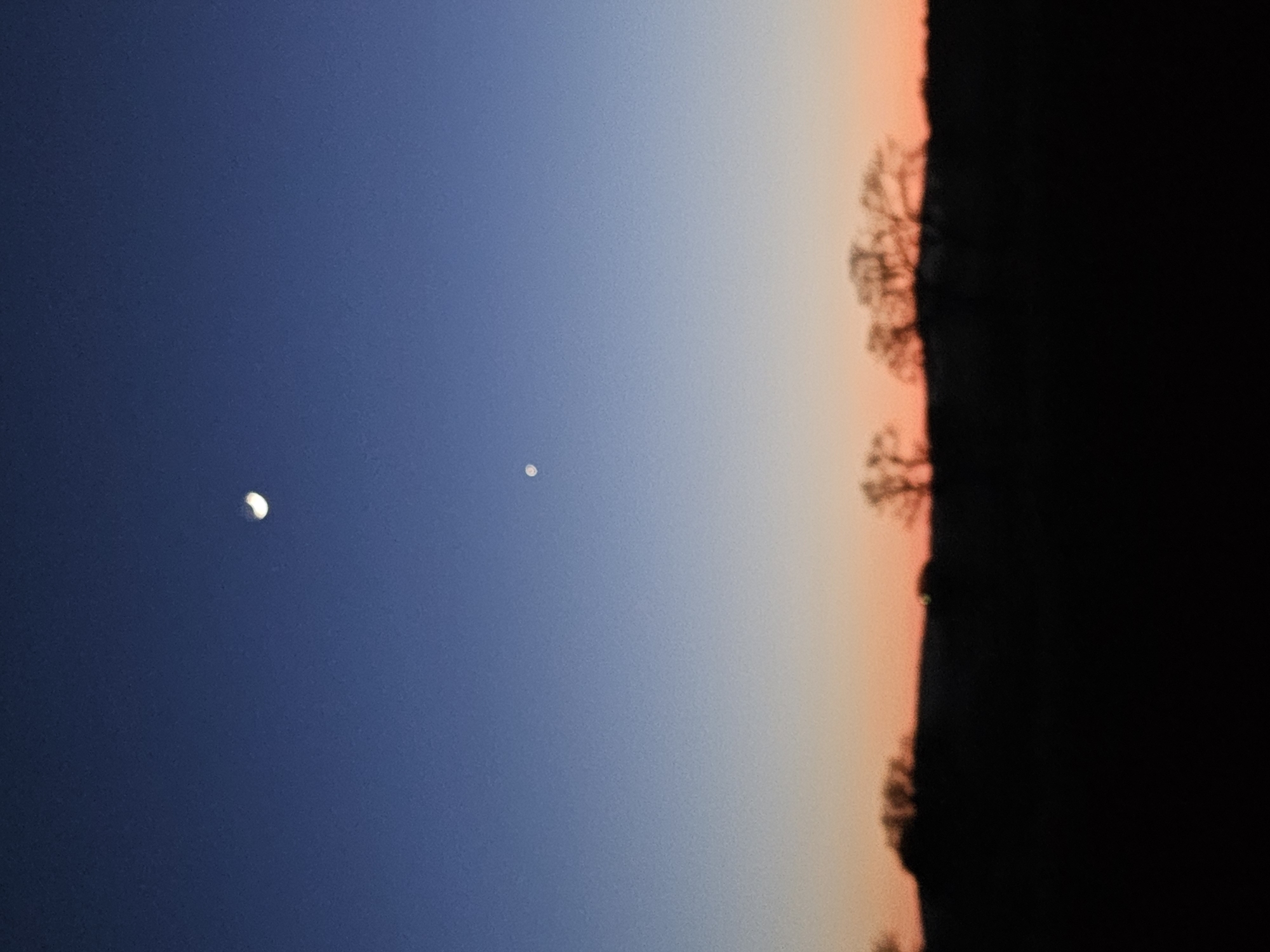 Crescent moon and bright celestial object observed during twilight