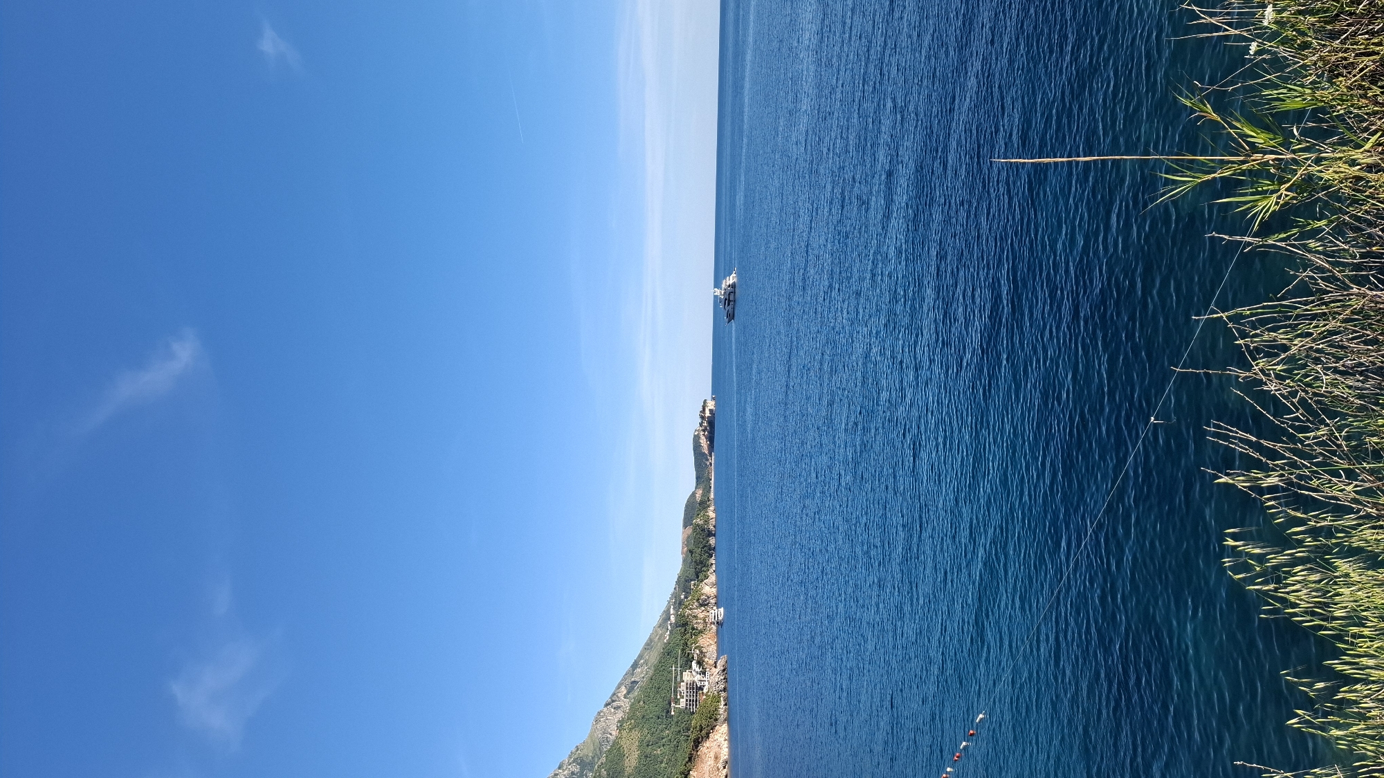 Ship observed near populated coastline under clear skies