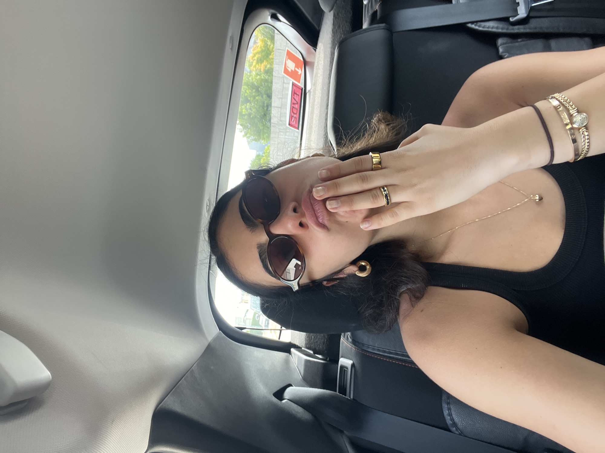 Back seat passenger in Porto wearing sunglasses and jewelry