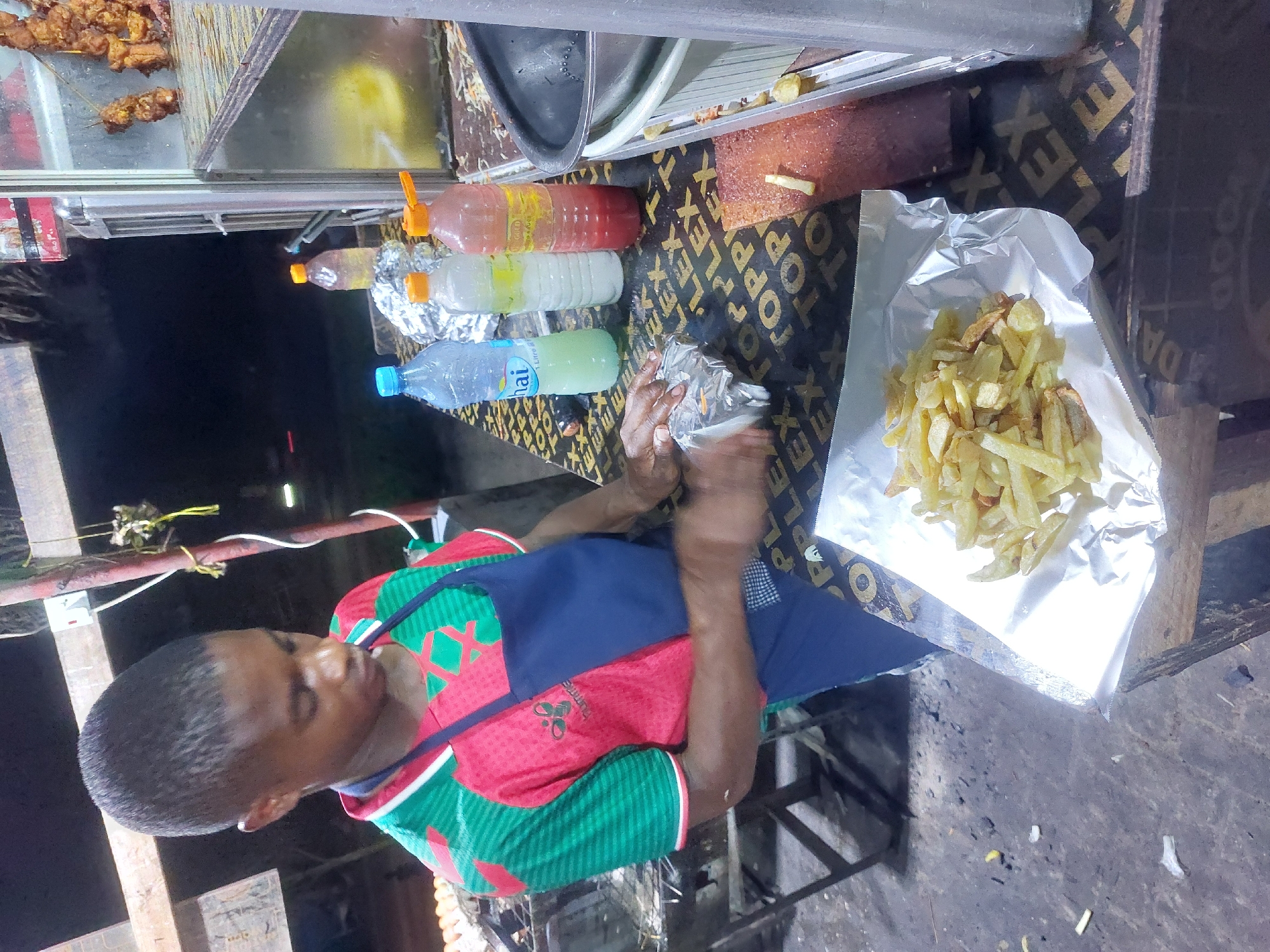 Street food vendor serves customers in Dar es-Salaam evening