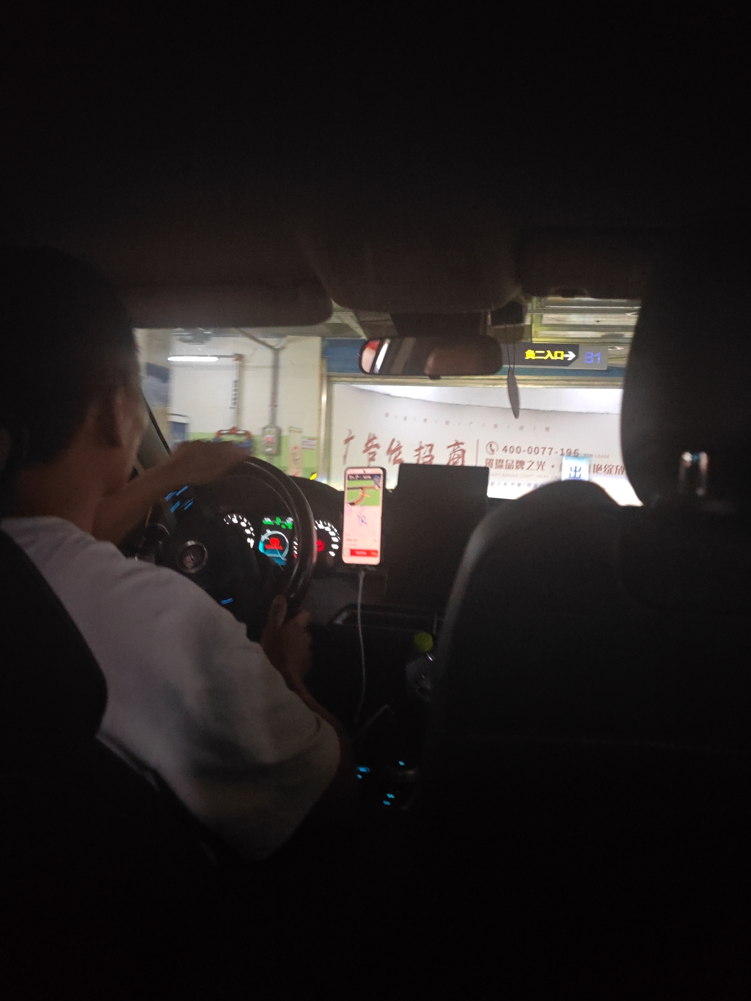 Driver in light clothing captured from rear passenger seat