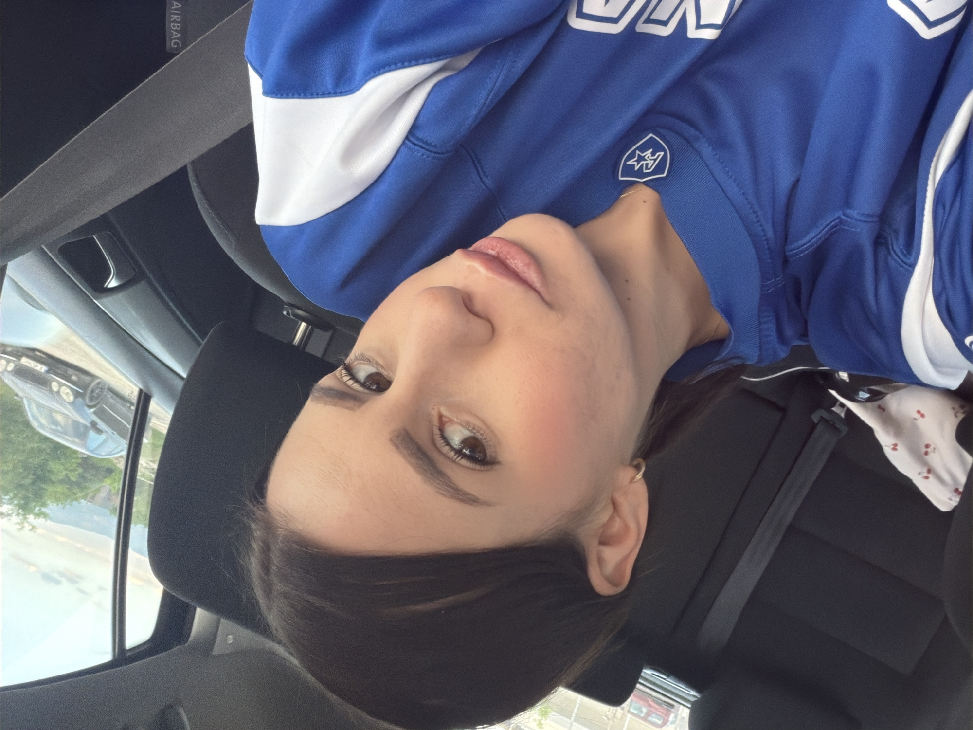 Woman in sports jersey sits in car in Plovdiv