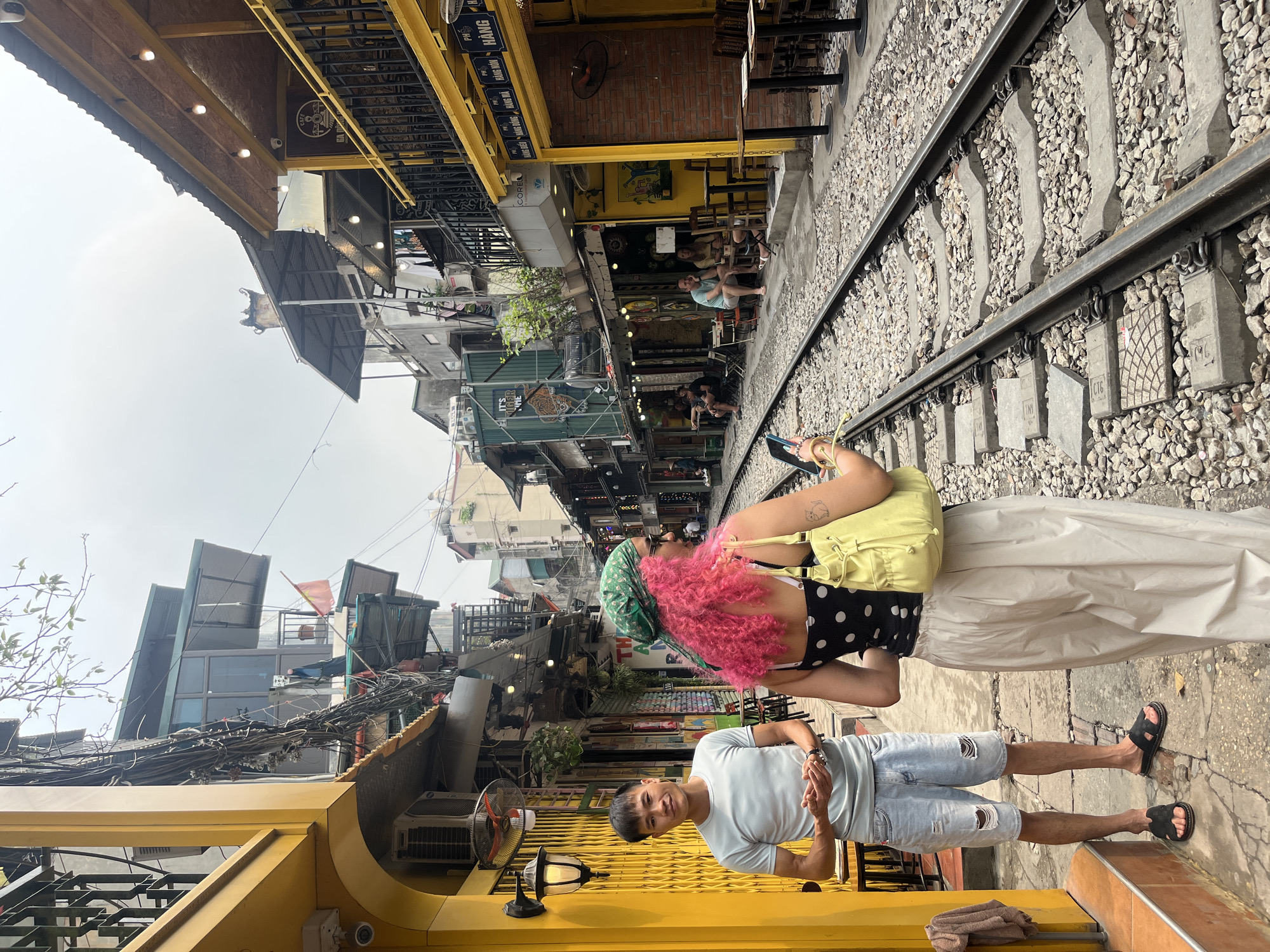Train tracks intersect narrow Hanoi street scene