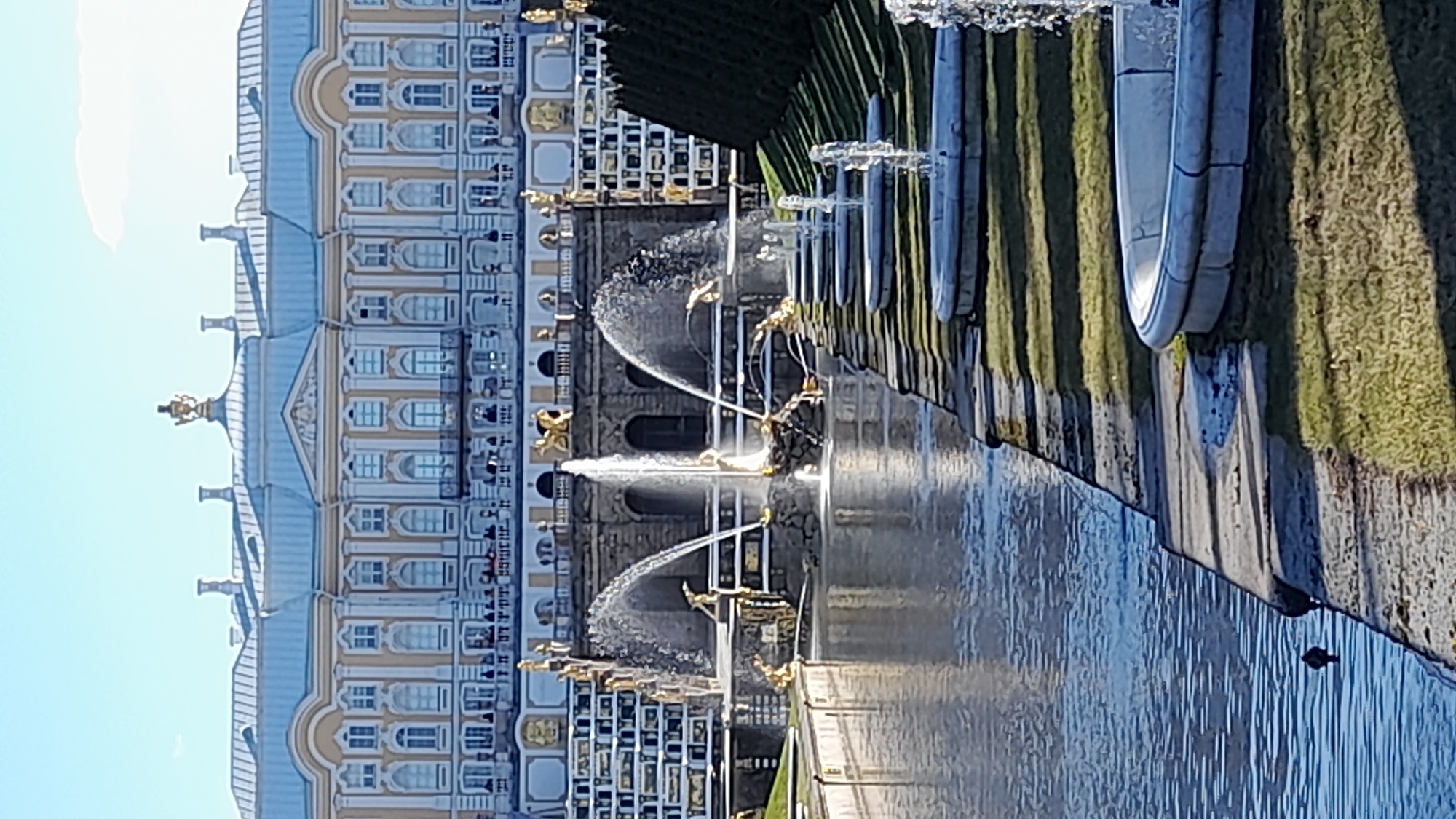 Visitors document Peterhof Palace fountains and bronze statue