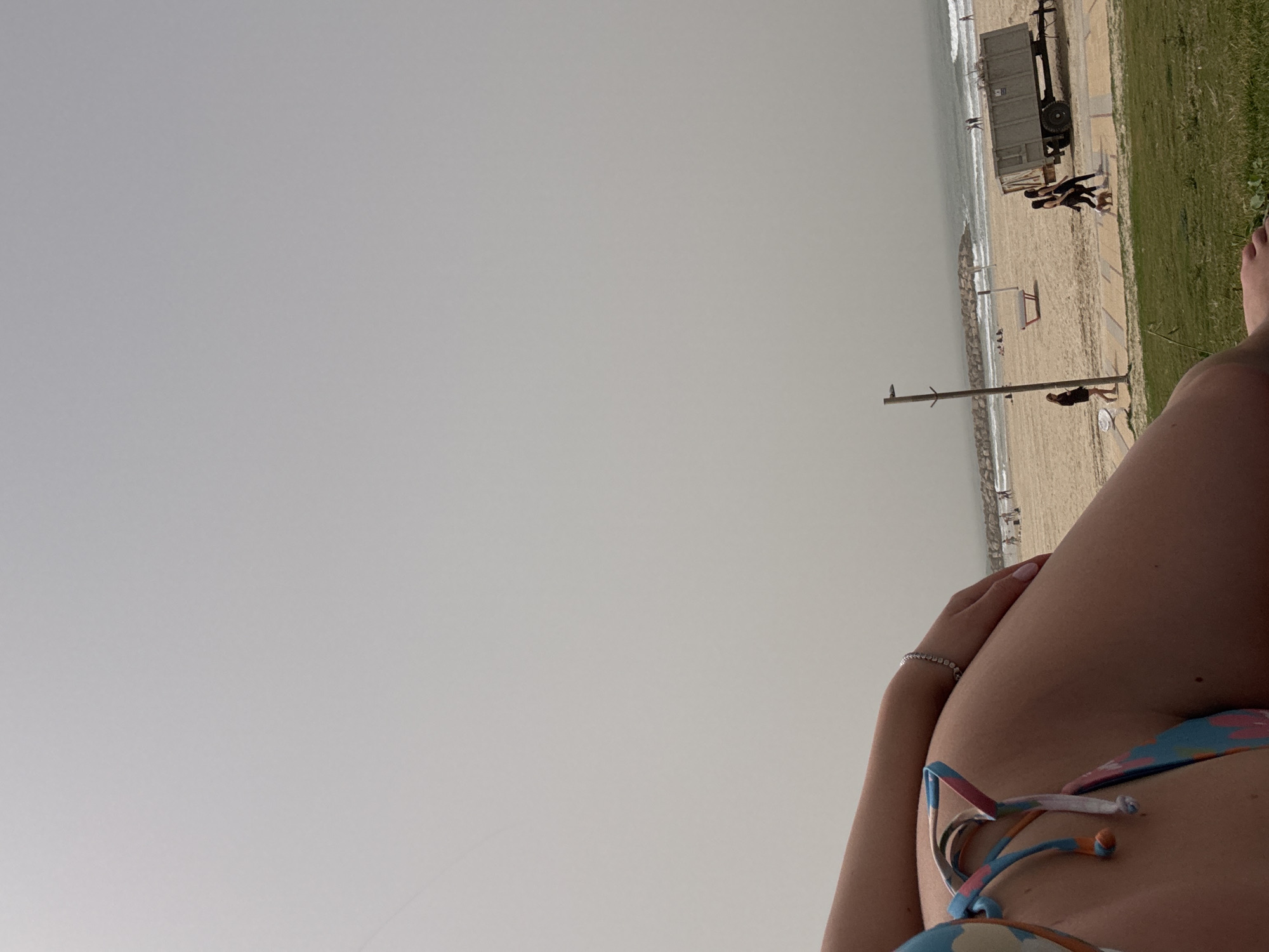 Beachgoer relaxes on overcast day at Herzliya beach