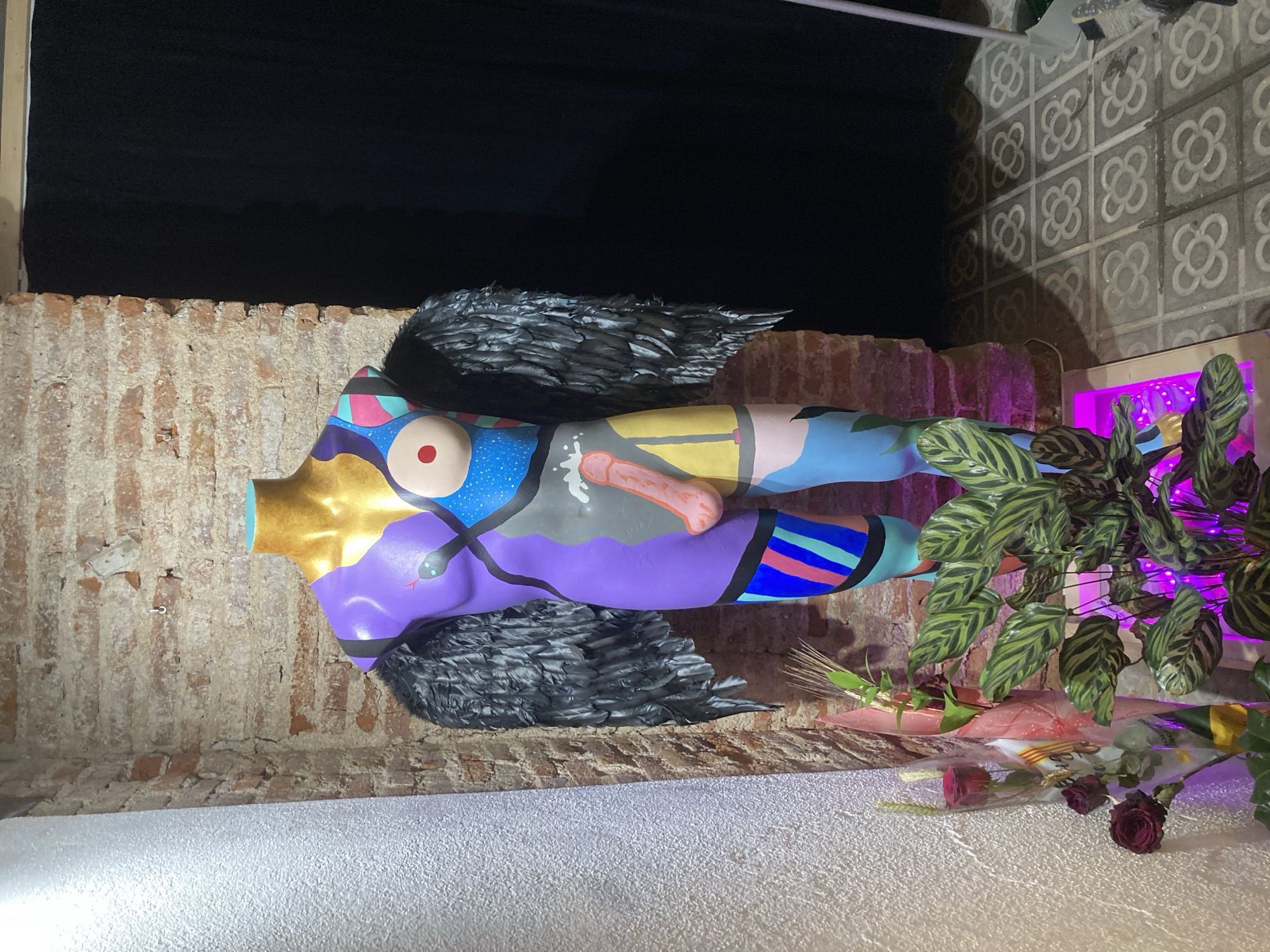 Artistic mannequin with abstract designs spotted in dimly lit area