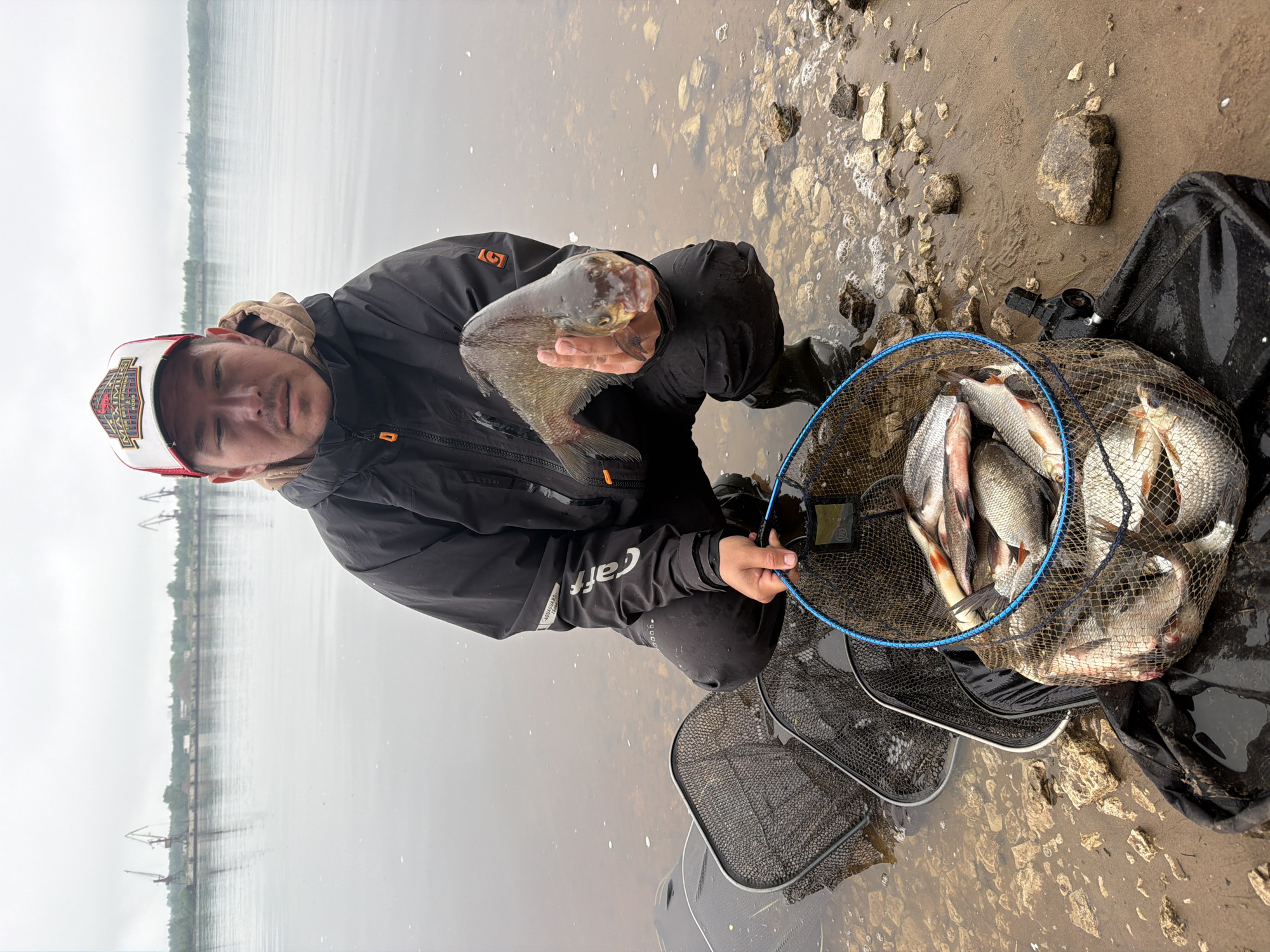 Angler catches fish in murky waters near Noviy, Russia