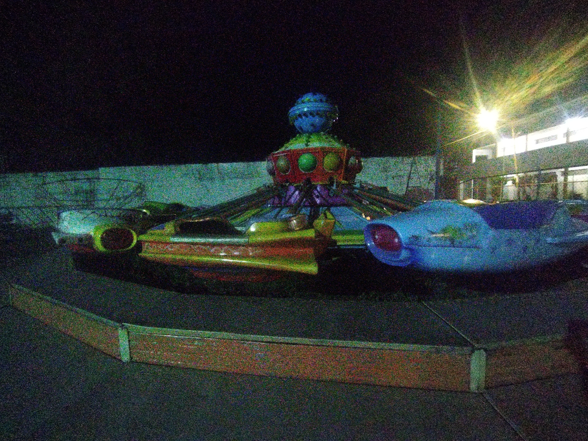 Nighttime carnival attractions observed with colorful rides and decorations