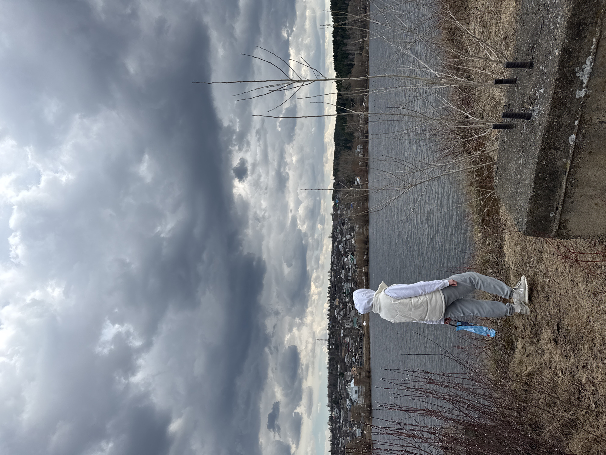 Residents enjoy waterfront walks in overcast Chaikovsky, Russia