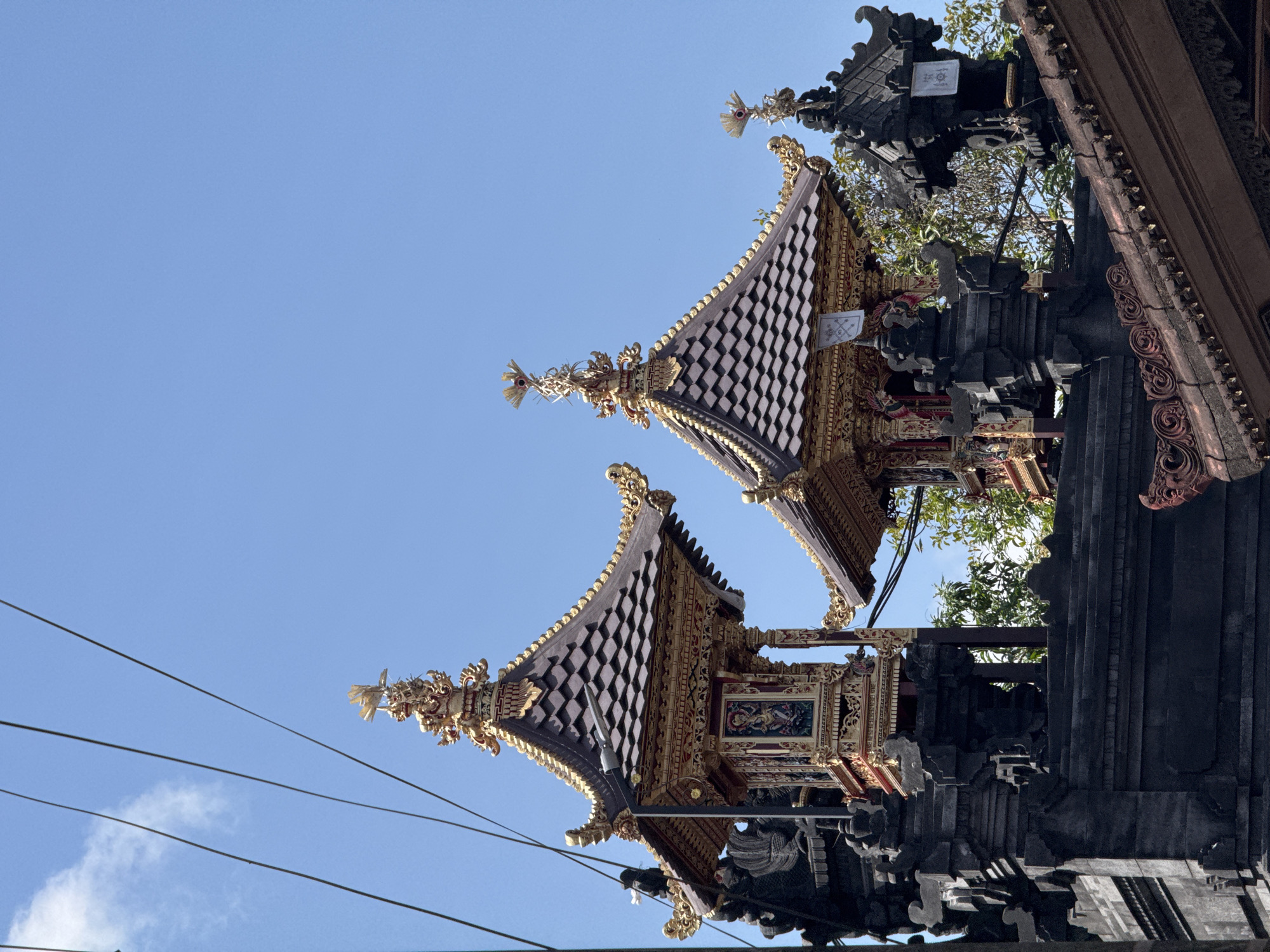 Ornate multi-tiered Balinese temple towers against clear blue sky