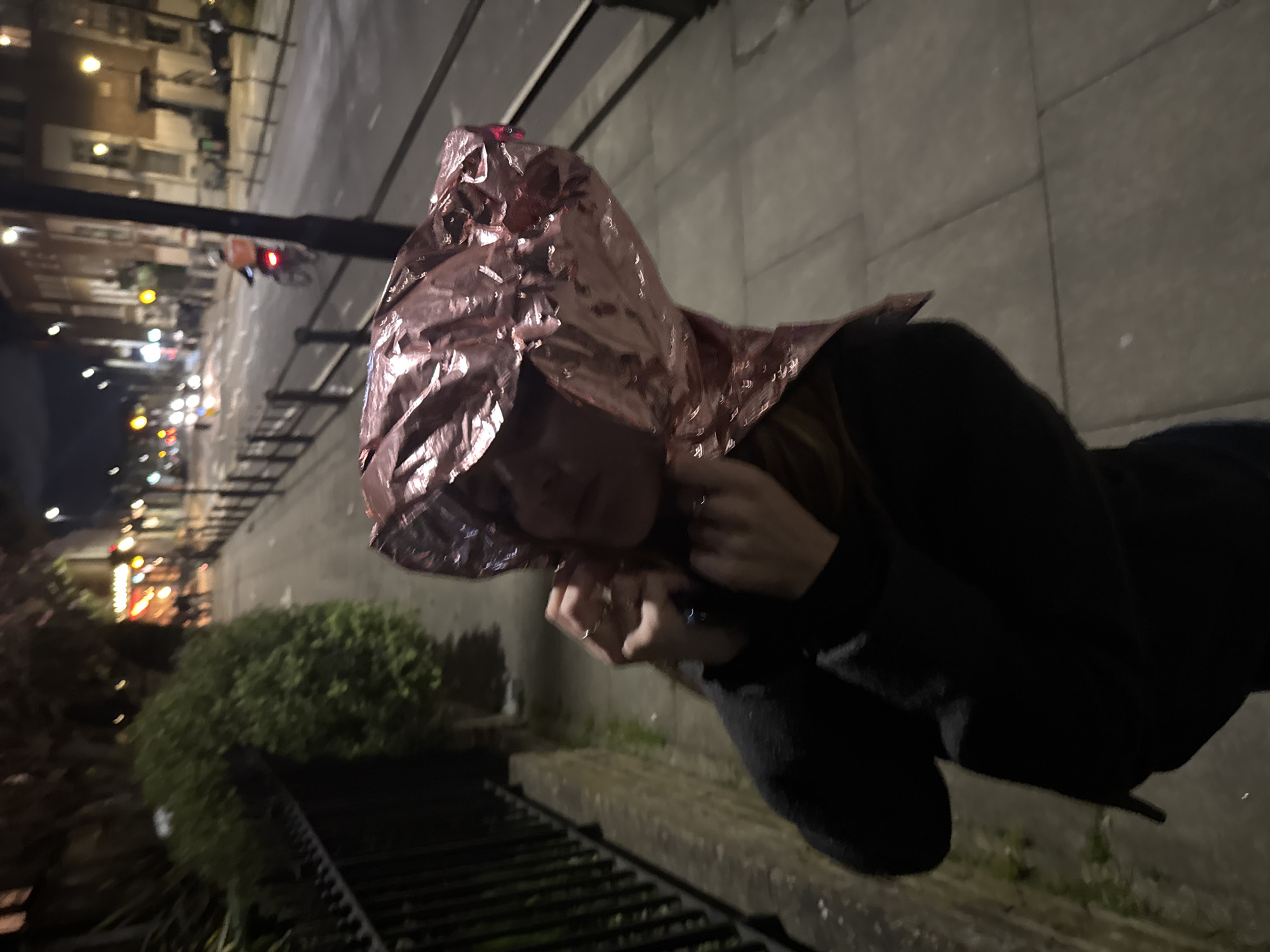 Person spotted wearing metallic hood on London street at night