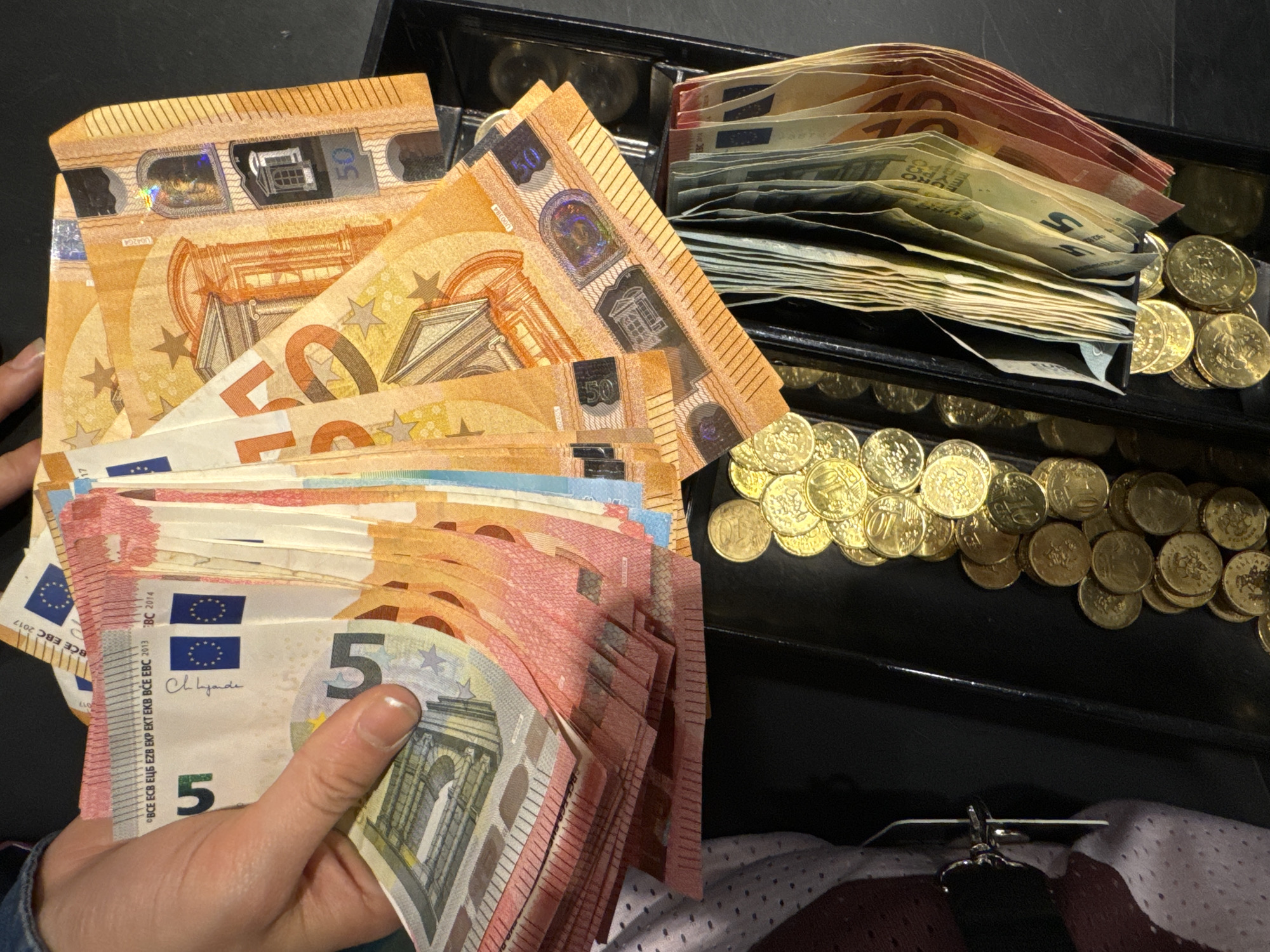 Person handles large amounts of Euro currency from register