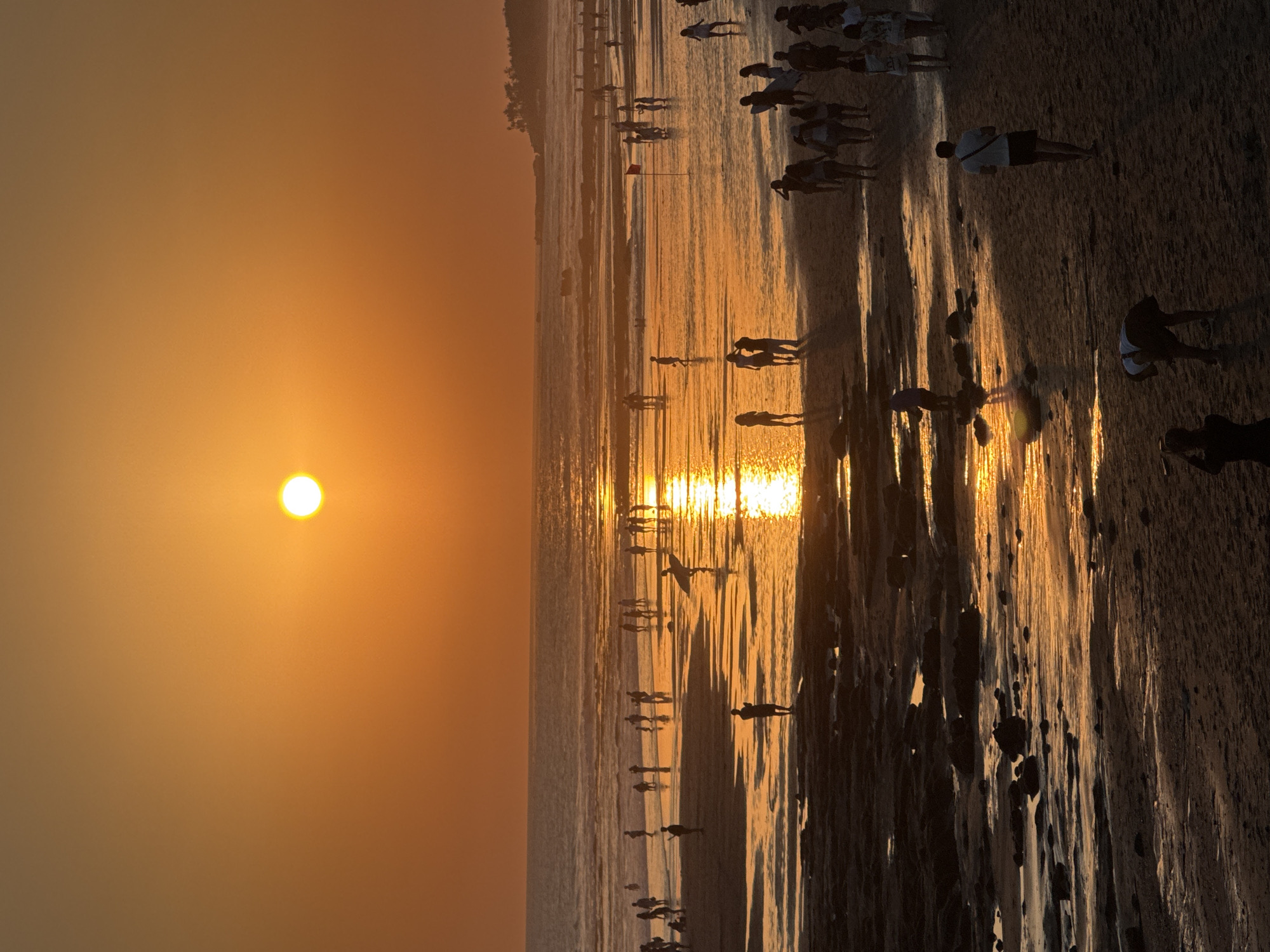 Sunset crowds, coastal rocks, and ceremony on Bali's west shore