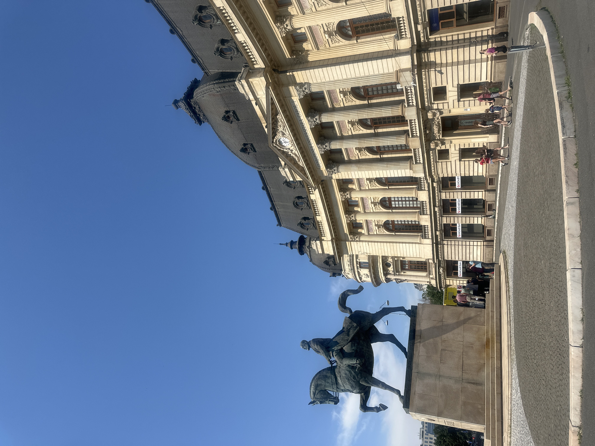 Equestrian monument outside a neoclassical building on a clear day