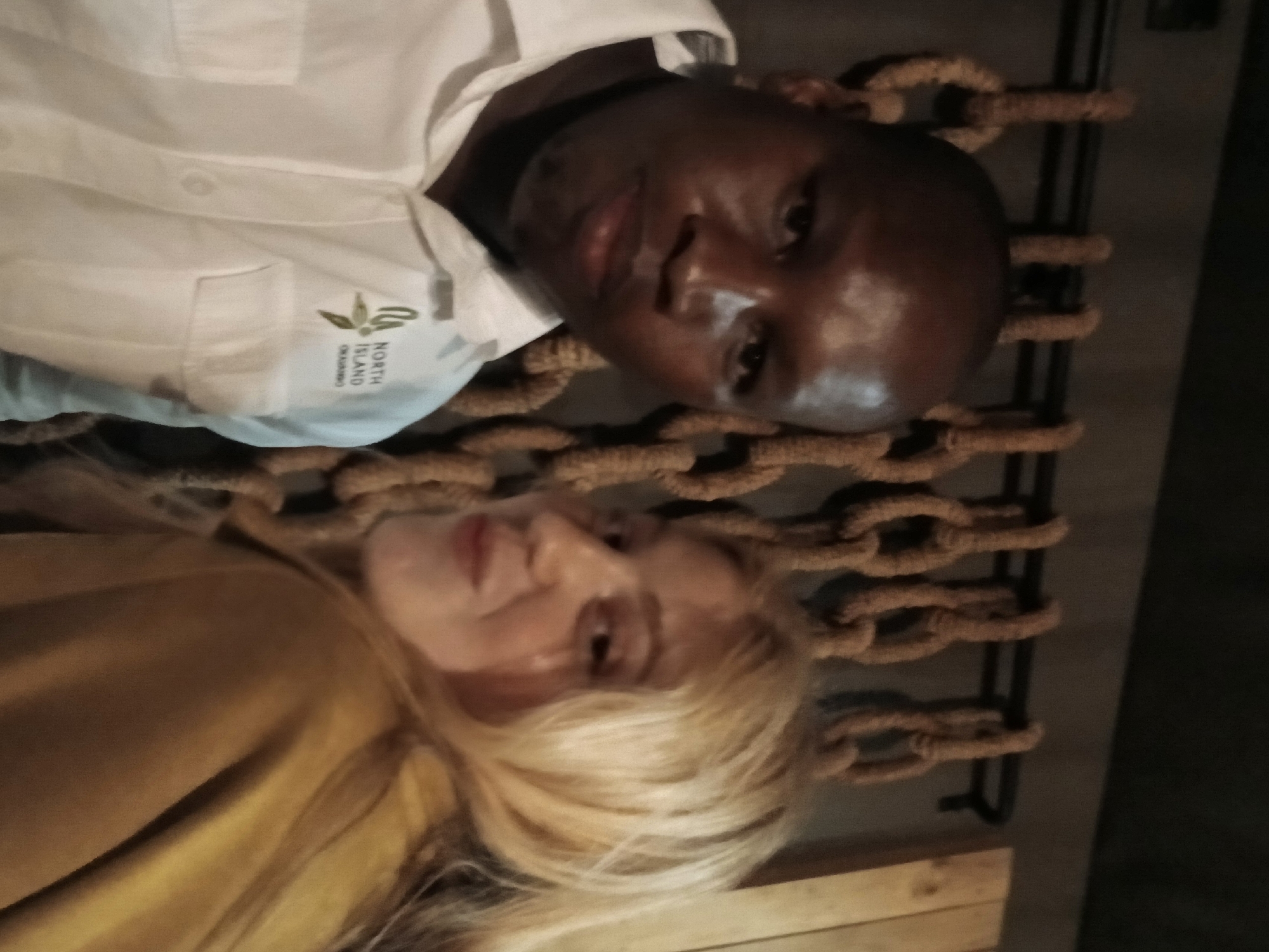 Two people rest in Nwanaeanoka, one wearing Seychelles shirt