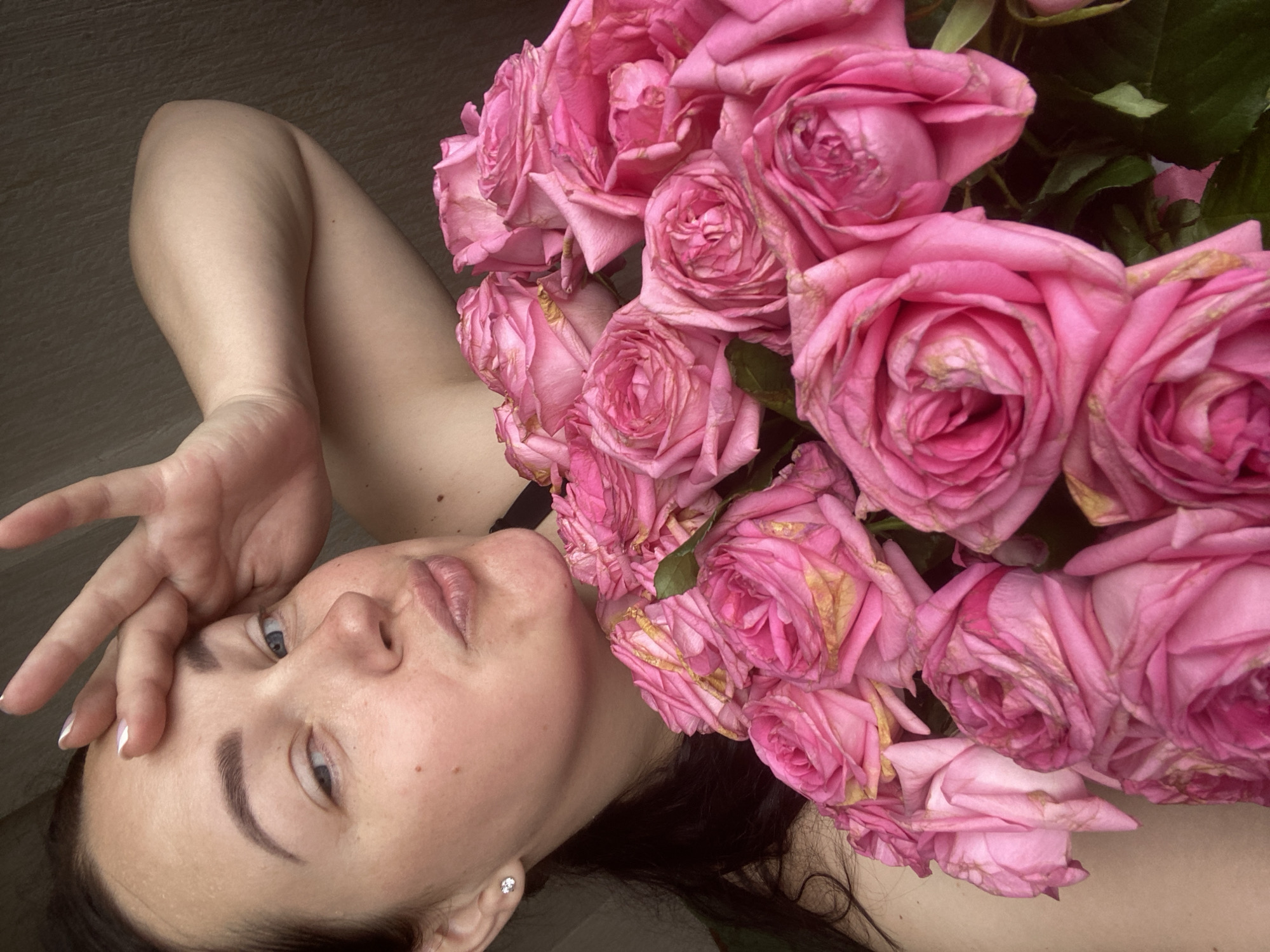 Woman photographed with pink roses in early morning Sochi session