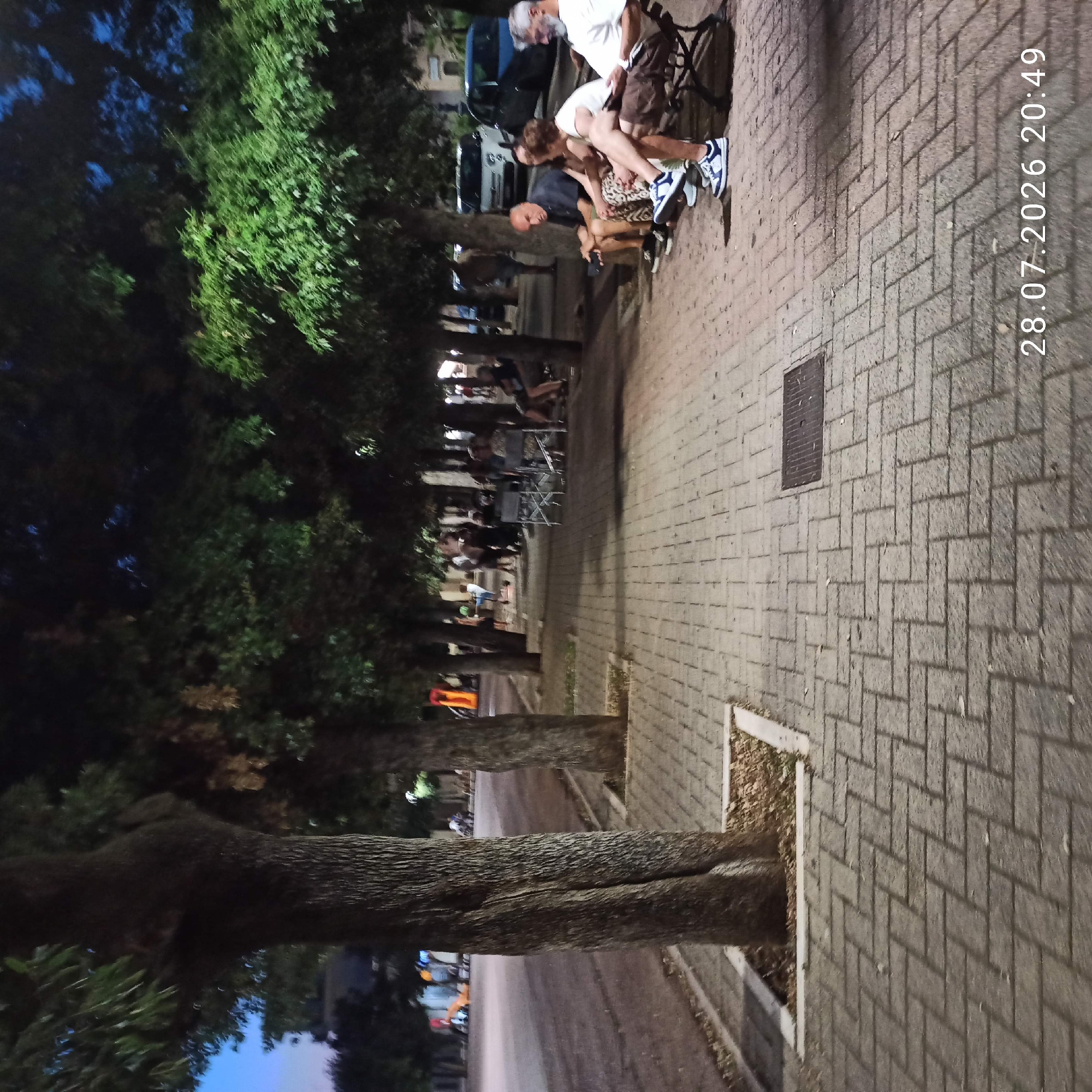 Summer evening on a Bitonto plaza, kids riding and locals unwinding