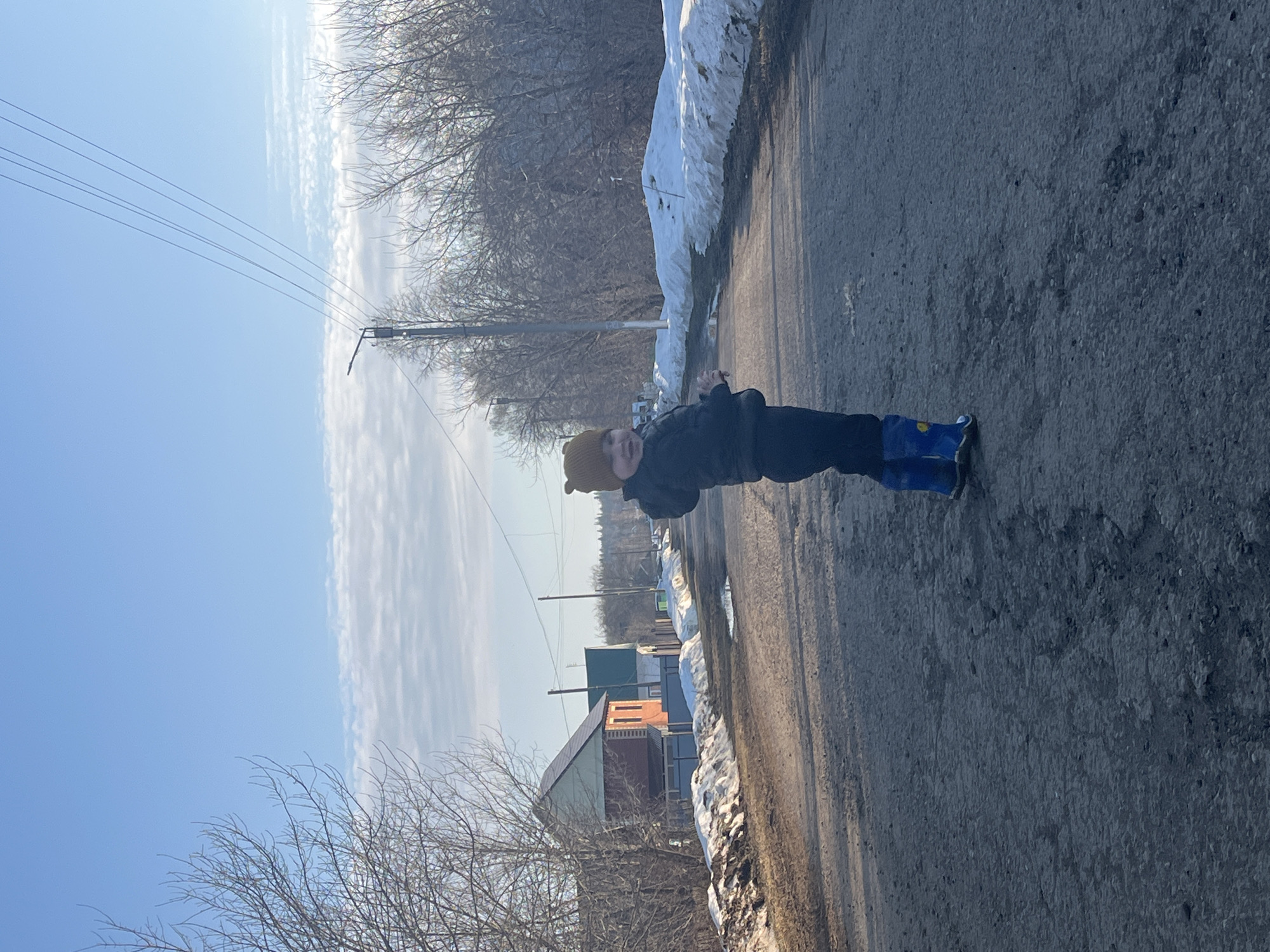 Child walks with dog on snowy street in Павловка